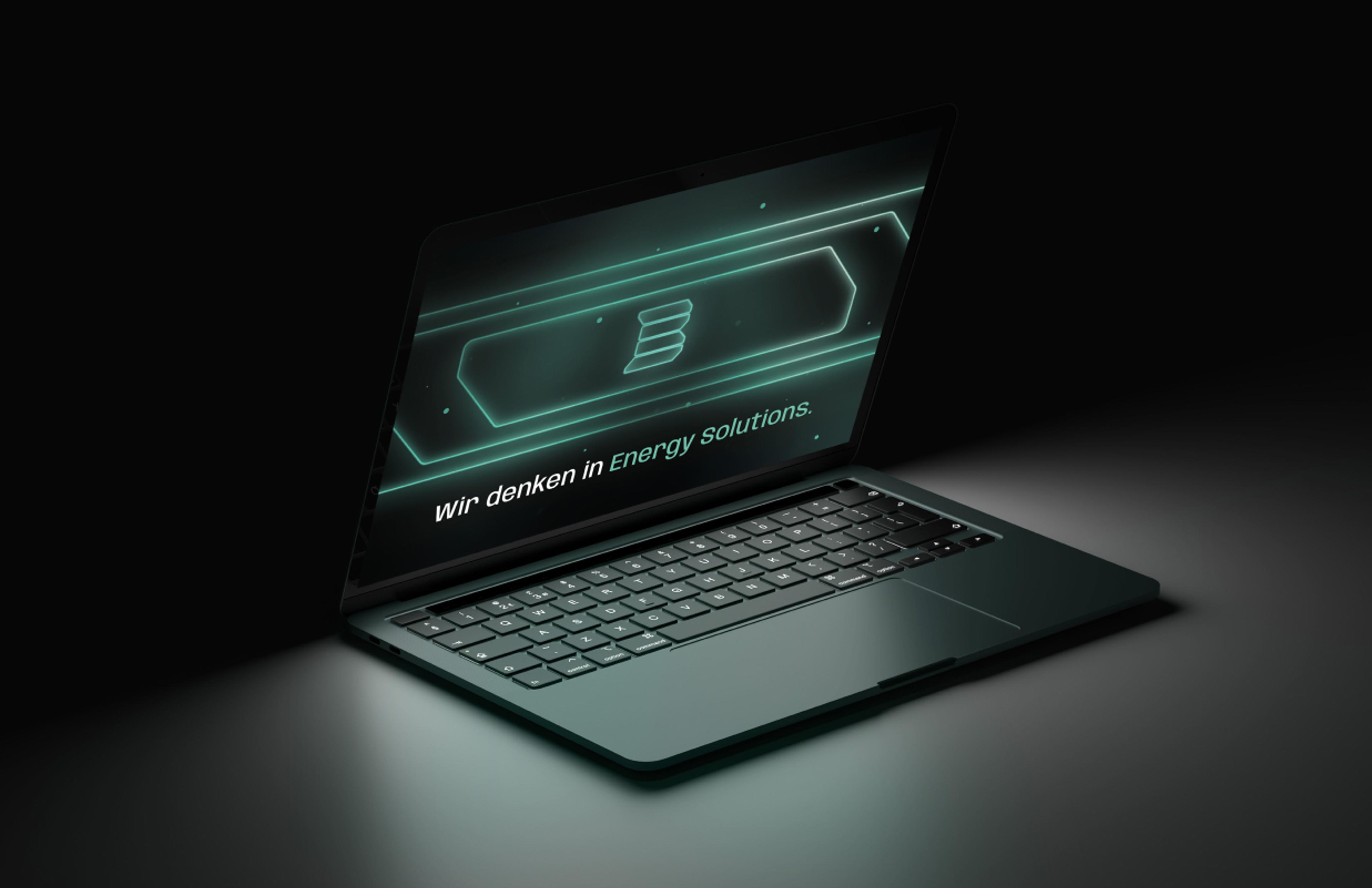Laptop mit der Markenbotschaft „Wir denken in Energy Solutions“ und grün leuchtender Grafik von Buron Energy Solutions.