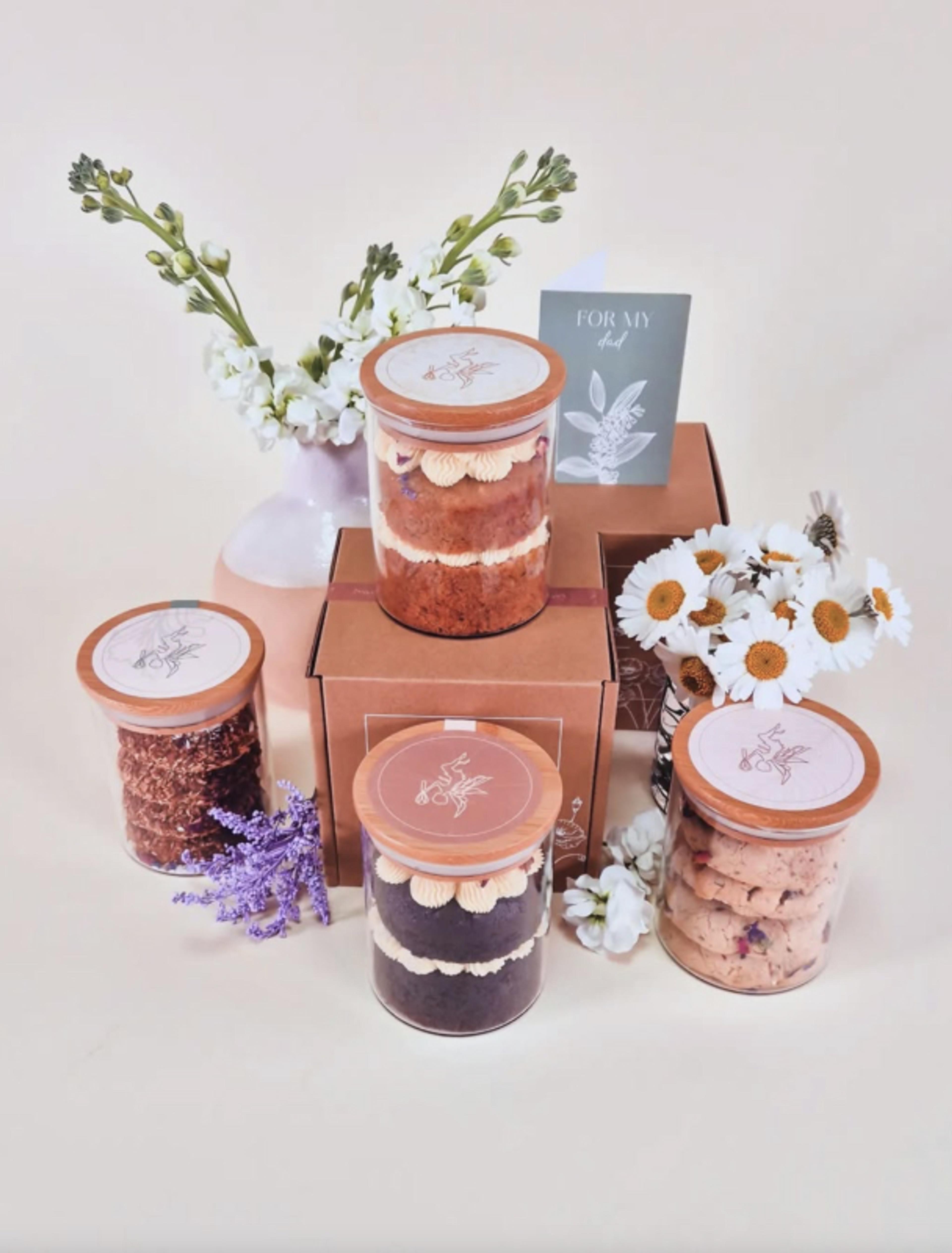 Sweetest Fairy | Sarah Frost Edle Verpackung für handgemachte Feinkostkuchen in hochwertigen Glasbehältern mit Holzdeckeln. Luxuriöse Präsentation mit floralen Akzenten und nachhaltiger Materialwahl, perfekt für exklusive Feinkostmarken, Patisserien und Premium-Geschenkverpackungen. Hochwertiges Design mit Liebe zum Detail, umgesetzt von Unerwartet Branding und Design OG aus Graz, Österreich.