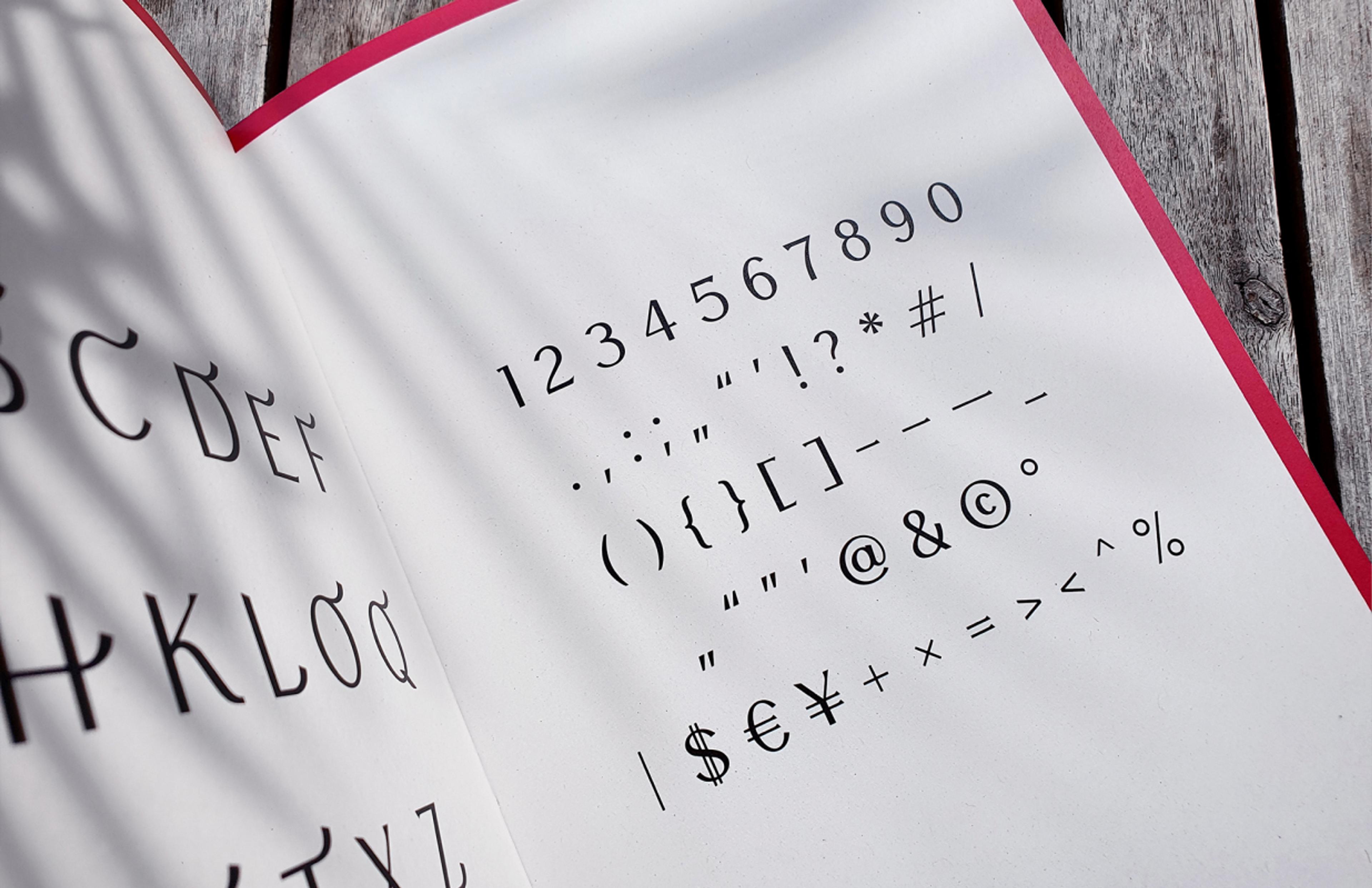 Detailaufnahme der Meilin-Schrift mit Symbolen und Zahlen in einem Typografie-Buch, gestaltet von Unerwartet Design in Graz.