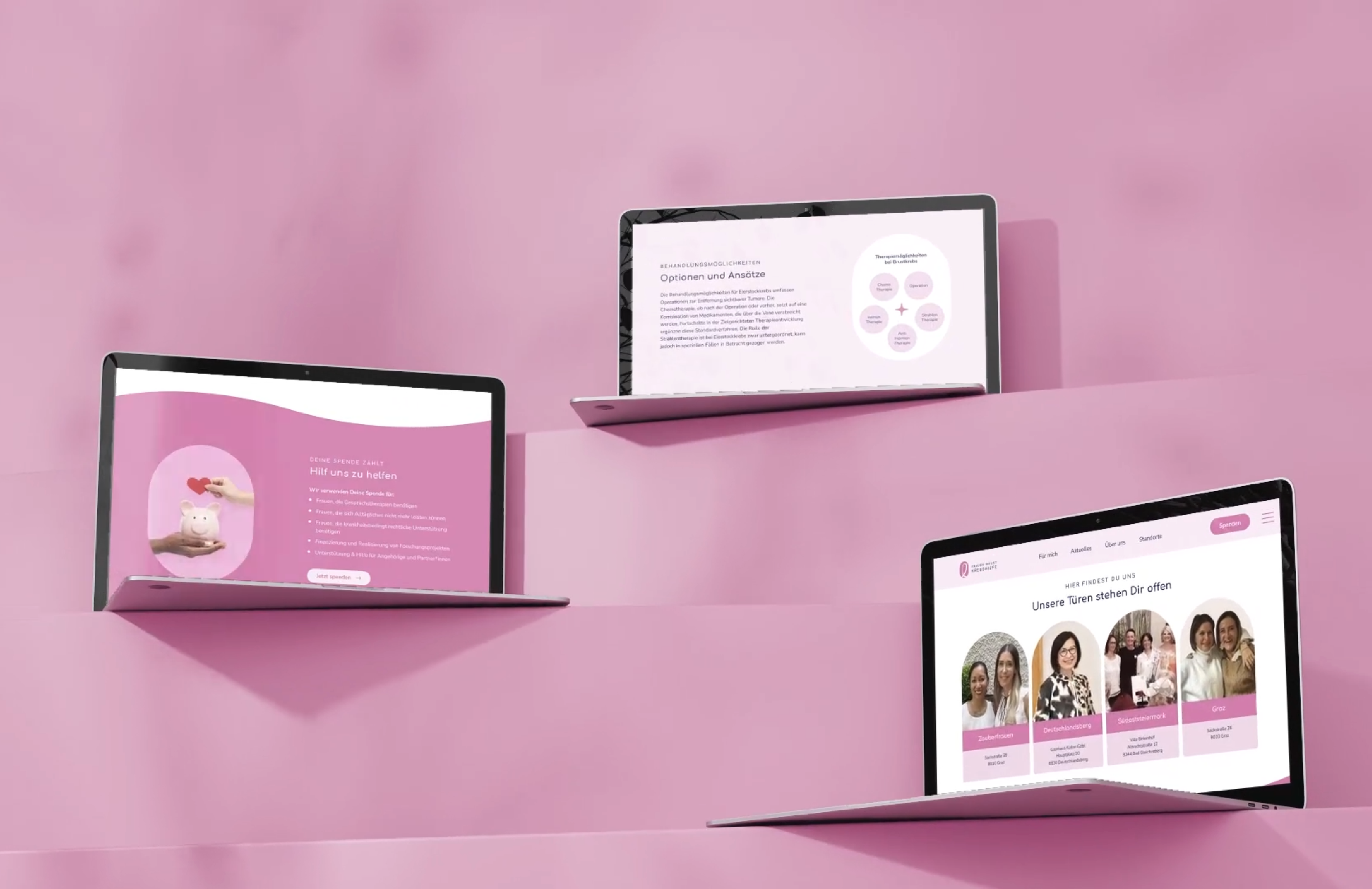 Drei Laptops die verschiedene Seiten der Brustkrebshilfe Webseite zeigt, in einem rosa Raum mit Stufen.