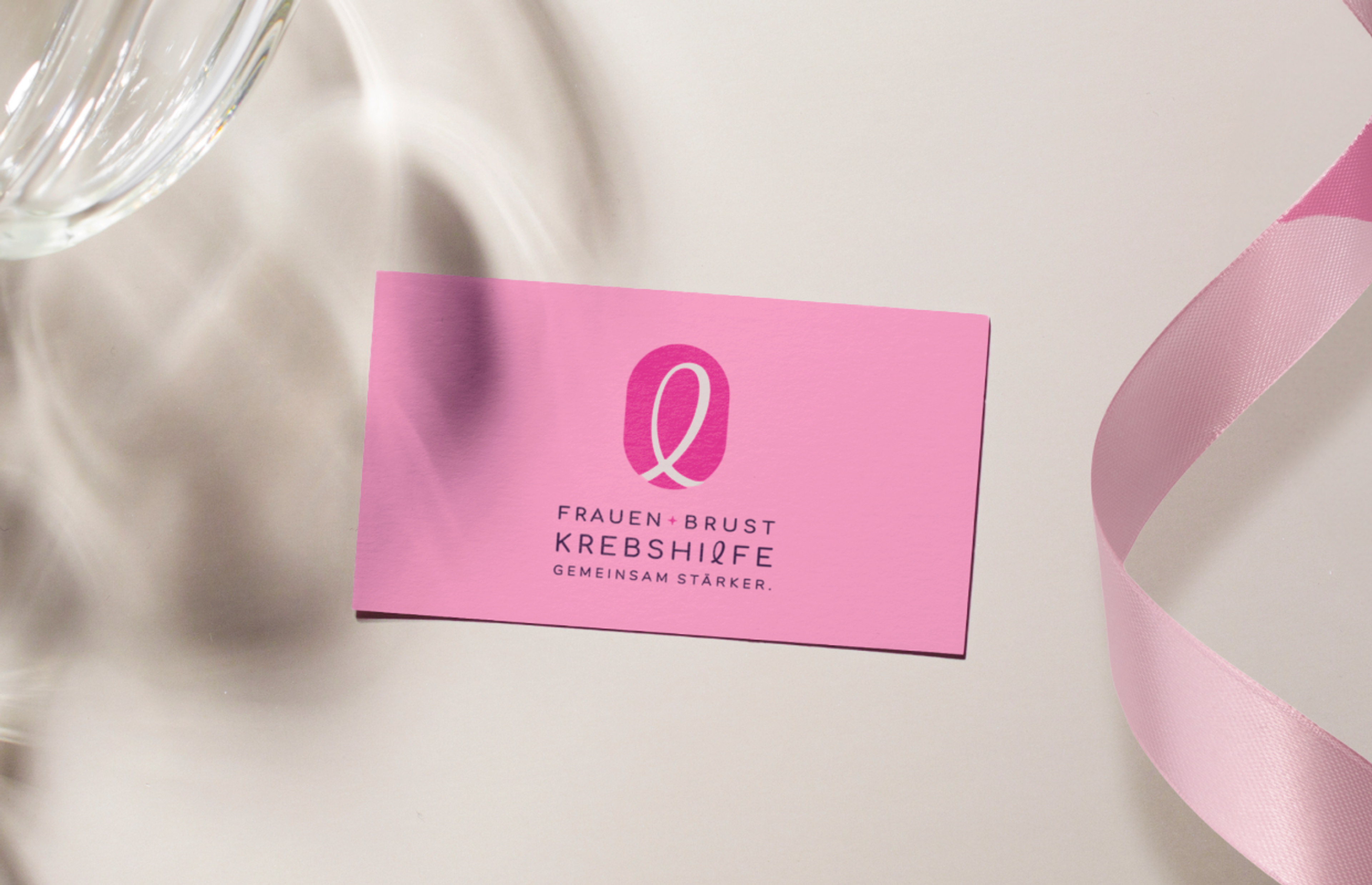 Edle Visitenkarte der Frauen- und Brustkrebshilfe Steiermark, dekoriert mit Satinband und Kristallglas – Unerwartet Design.