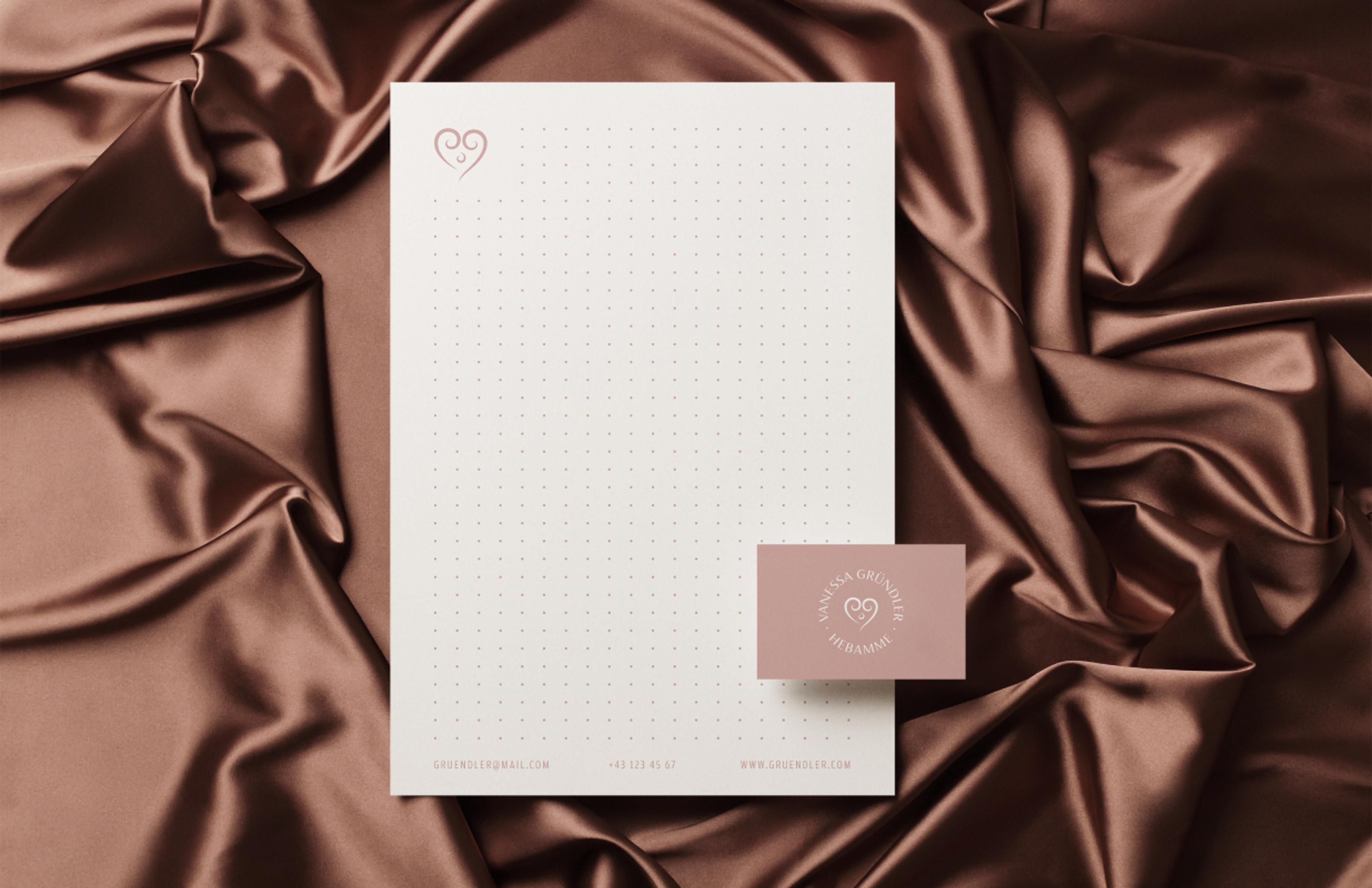 Edles Branding mit Visitenkarte auf strukturiertem Stoff. Die warme Farbpalette in Braun und Rosé unterstreicht die Werte von Vanessa Gründler: Empathie, Geborgenheit und professionelle Betreuung.