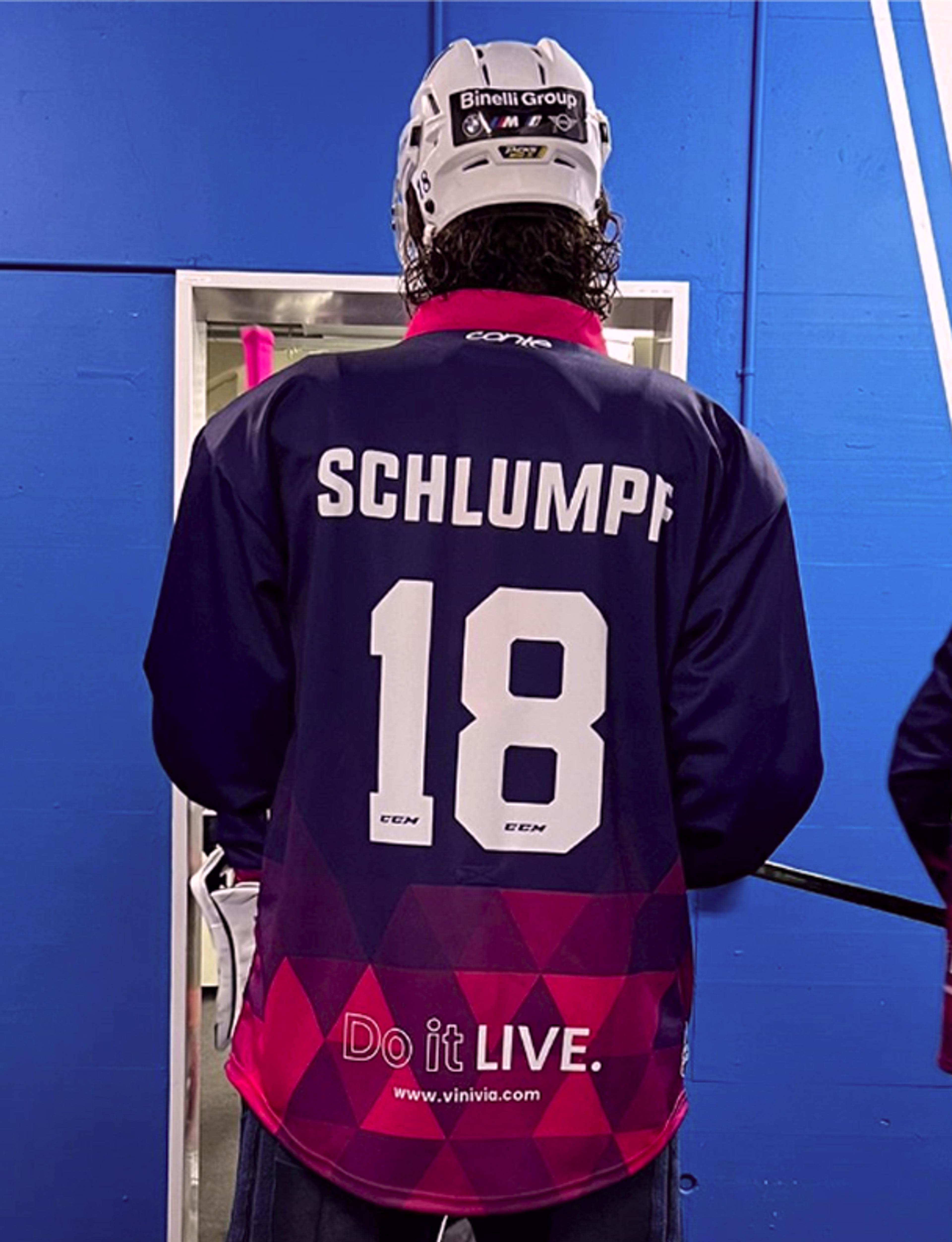 vinivia Rückansicht eines EVZ-Spielers mit "Schlumpf 18" auf dem Trikot und Vinivia-Branding, aufgenommen in der Vinivia Ice Hockey Lounge – Unerwartet Design
