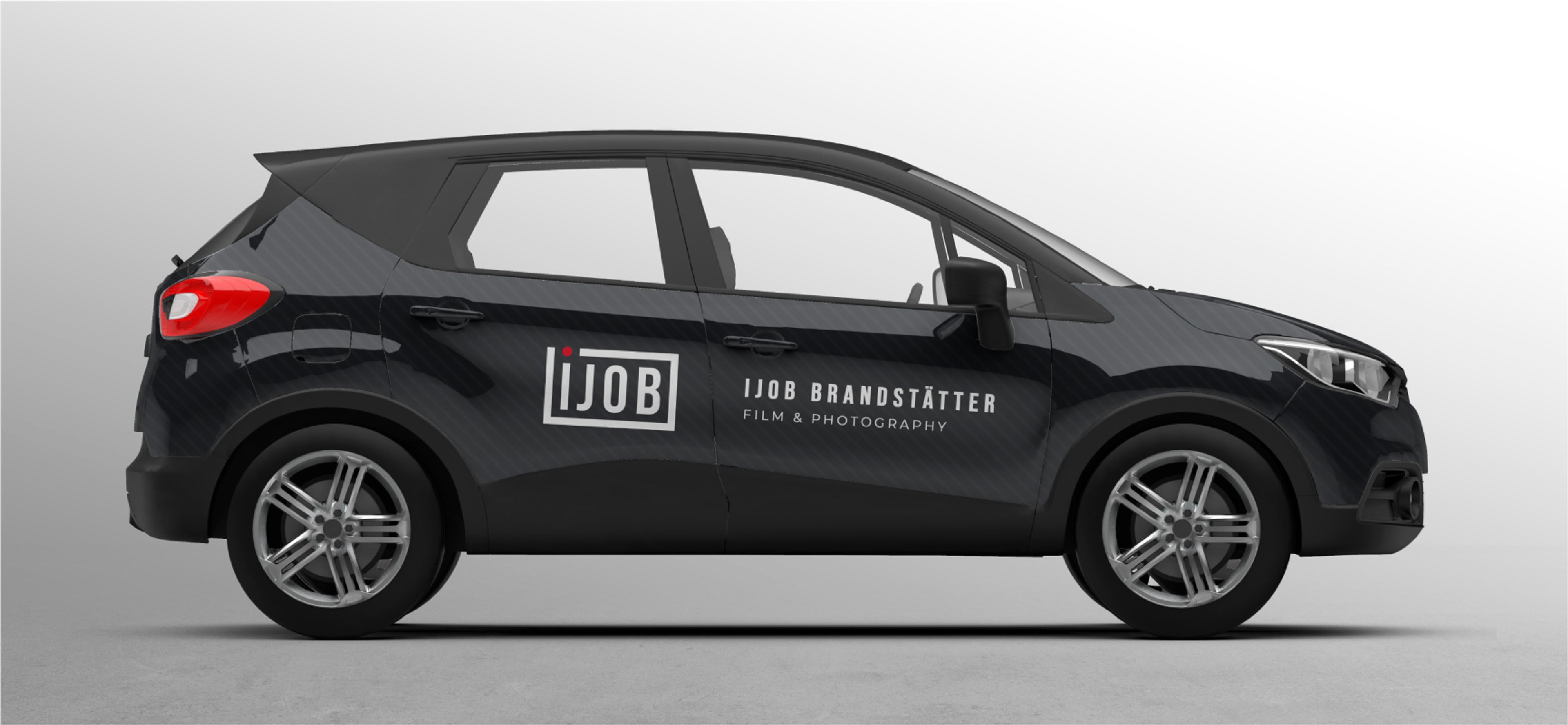 Gebrandetes Firmenfahrzeug für Ijob Film & Photography – Ein schwarzer SUV mit Ijob-Branding, darunter das weiße Ijob-Logo mit rotem Punkt und der Schriftzug „Ijob Brandstätter – Film & Photography“ auf der Fahrzeugseite. Die Rücklichter sind in auffälligem Rot gehalten.