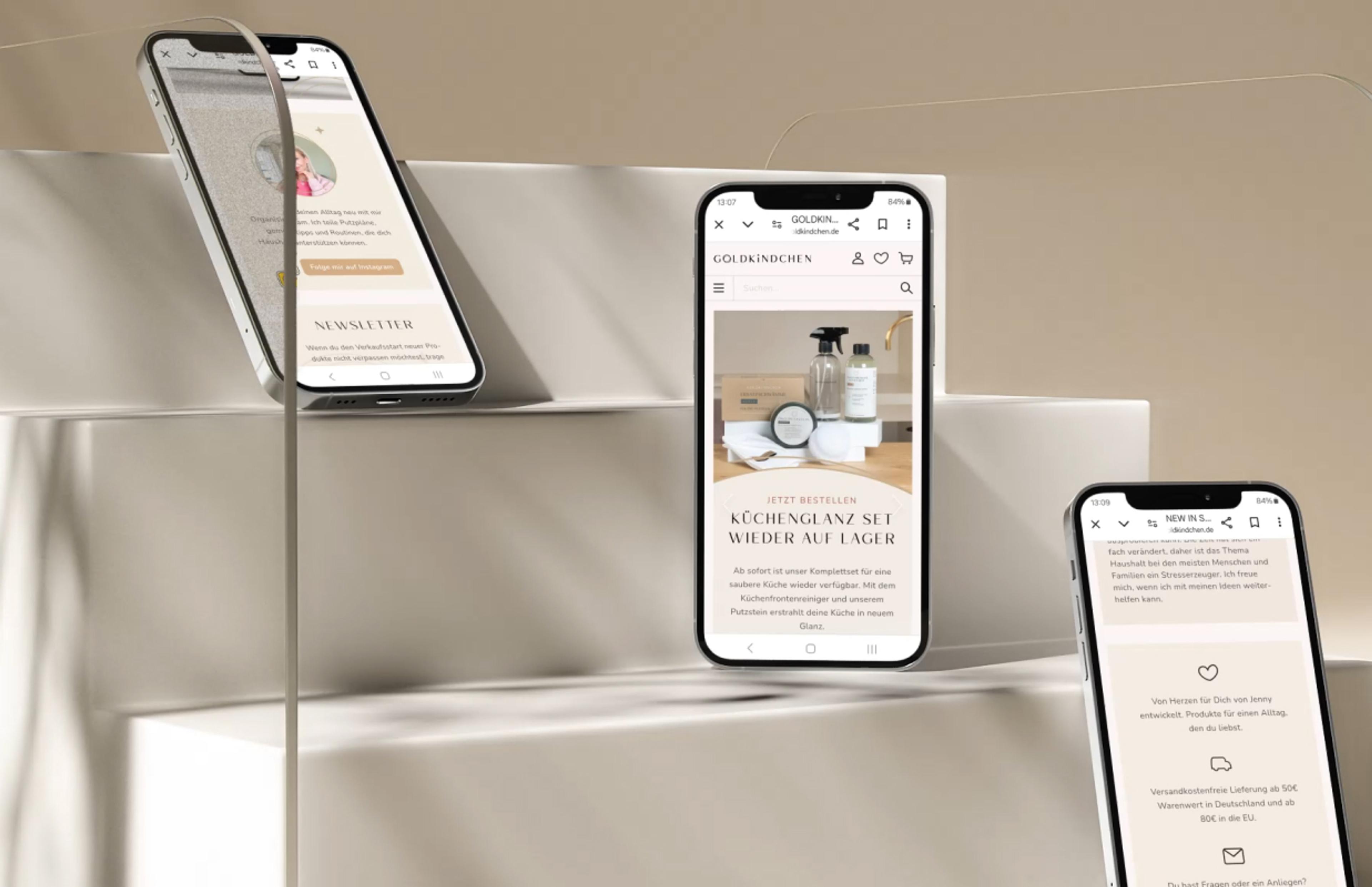 Drei Smartphones zeigen das moderne Webshop-Design von Goldkindchen mit Produktpräsentationen und Kundeninfos.