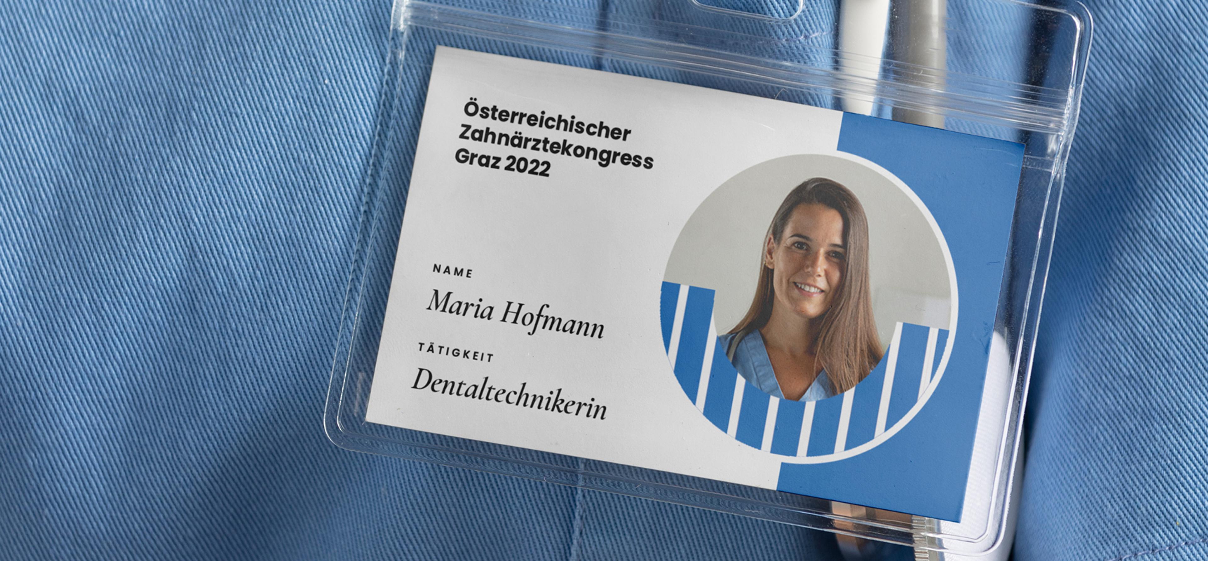 Nahaufnahme eines Namensschilds für Maria Hofmann, Dentaltechnikerin, beim Österreichischen Zahnärztekongress Graz 2022, getragen an blauer Berufskleidung, Design von Unverwartet Design.