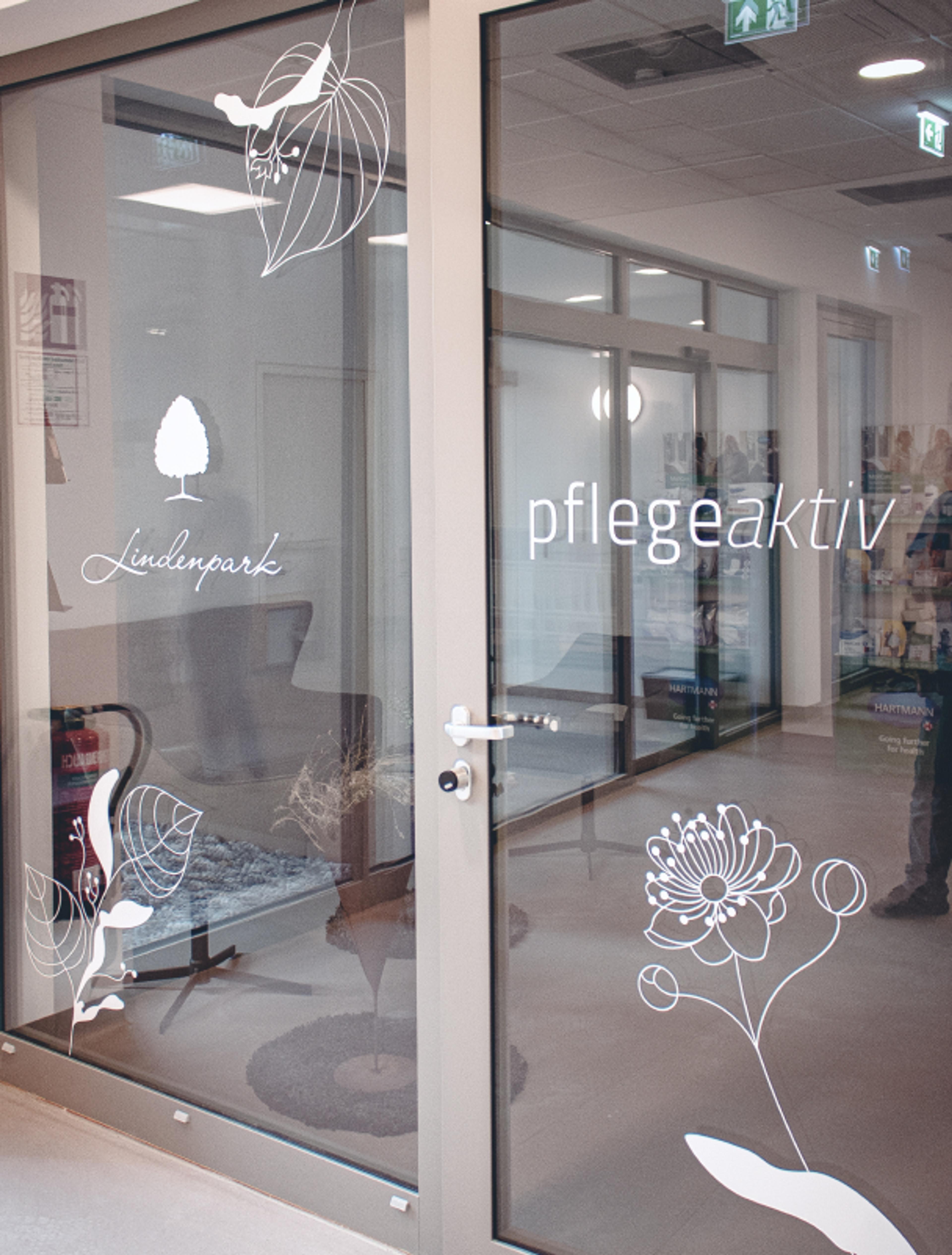 Logo & Grundkonzept BUCHER BRAND MARKETING e.U. Glastür mit floralen Elementen und dem Logo von Pflege Aktiv im Lindenpark Gesundheitszentrum, Teil des harmonischen Designkonzepts von Unerwartet Design.