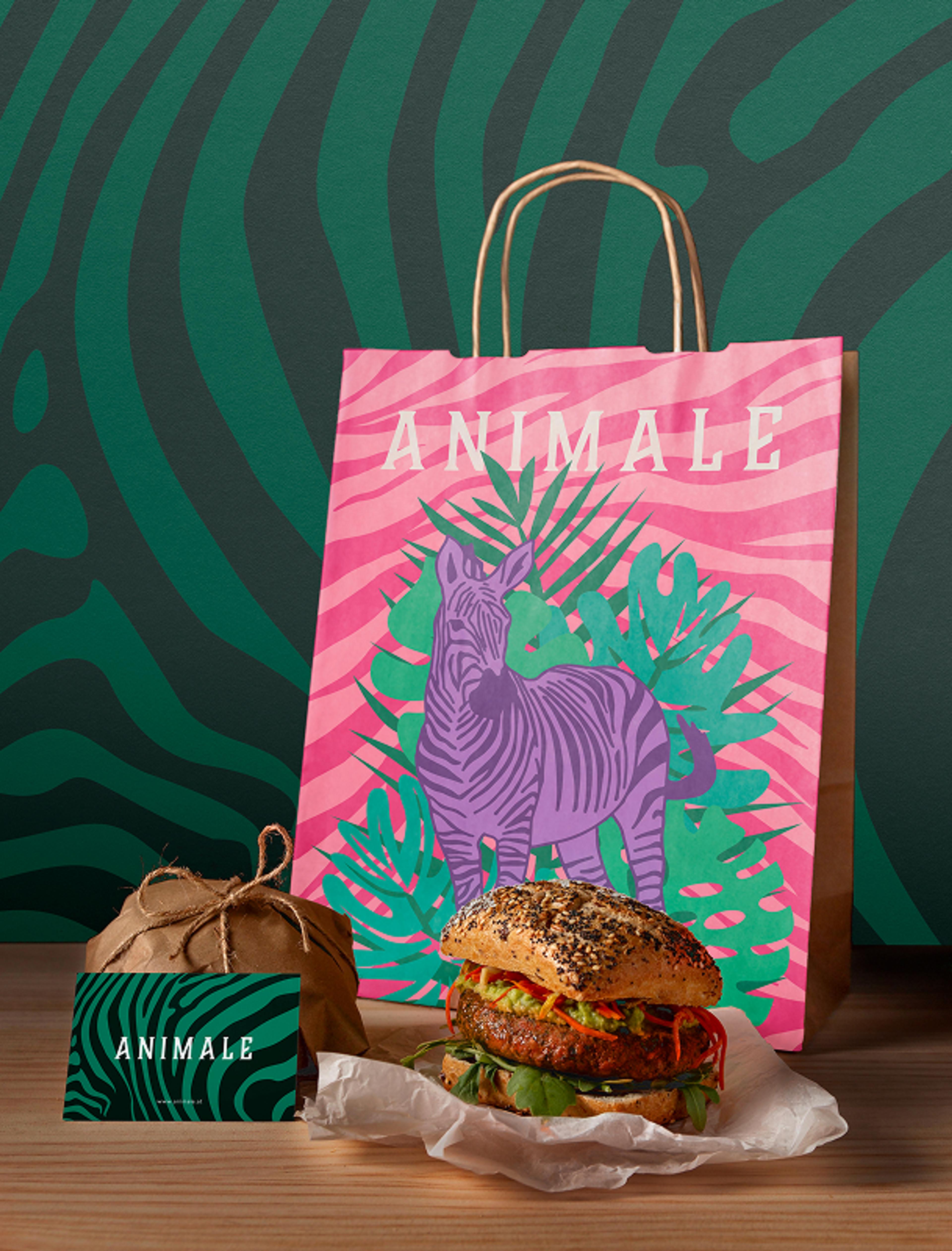osa Einkaufstasche mit lila Zebra-Illustration, daneben eine Burger-Verpackung, eine Visitenkarte und ein frischer Burger.