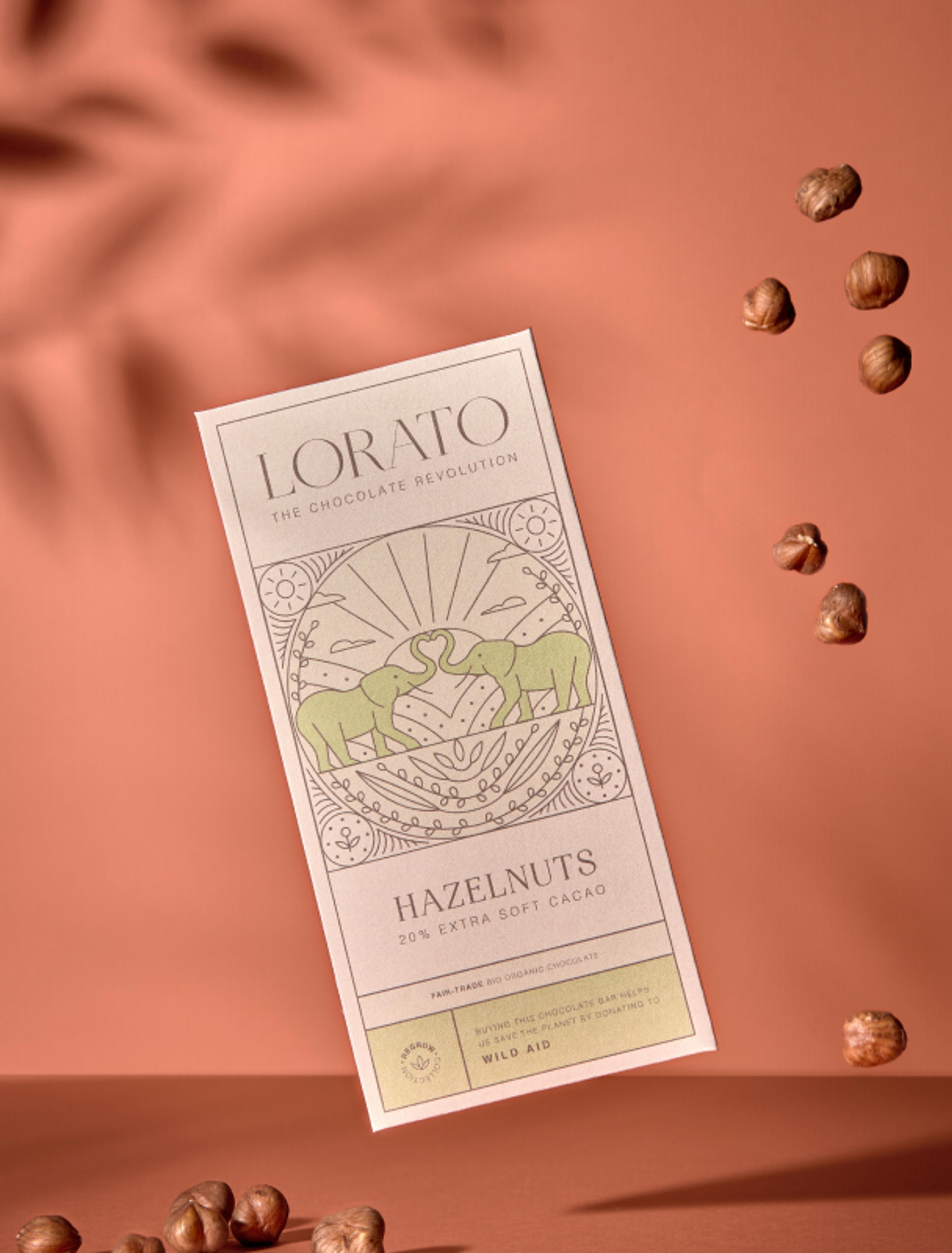 Die Hazelnuts Schokoladentafel von Lorato mit kunstvoller Illustration zweier Elefanten. Warme Braun- und Grüntöne betonen die nussige Note.