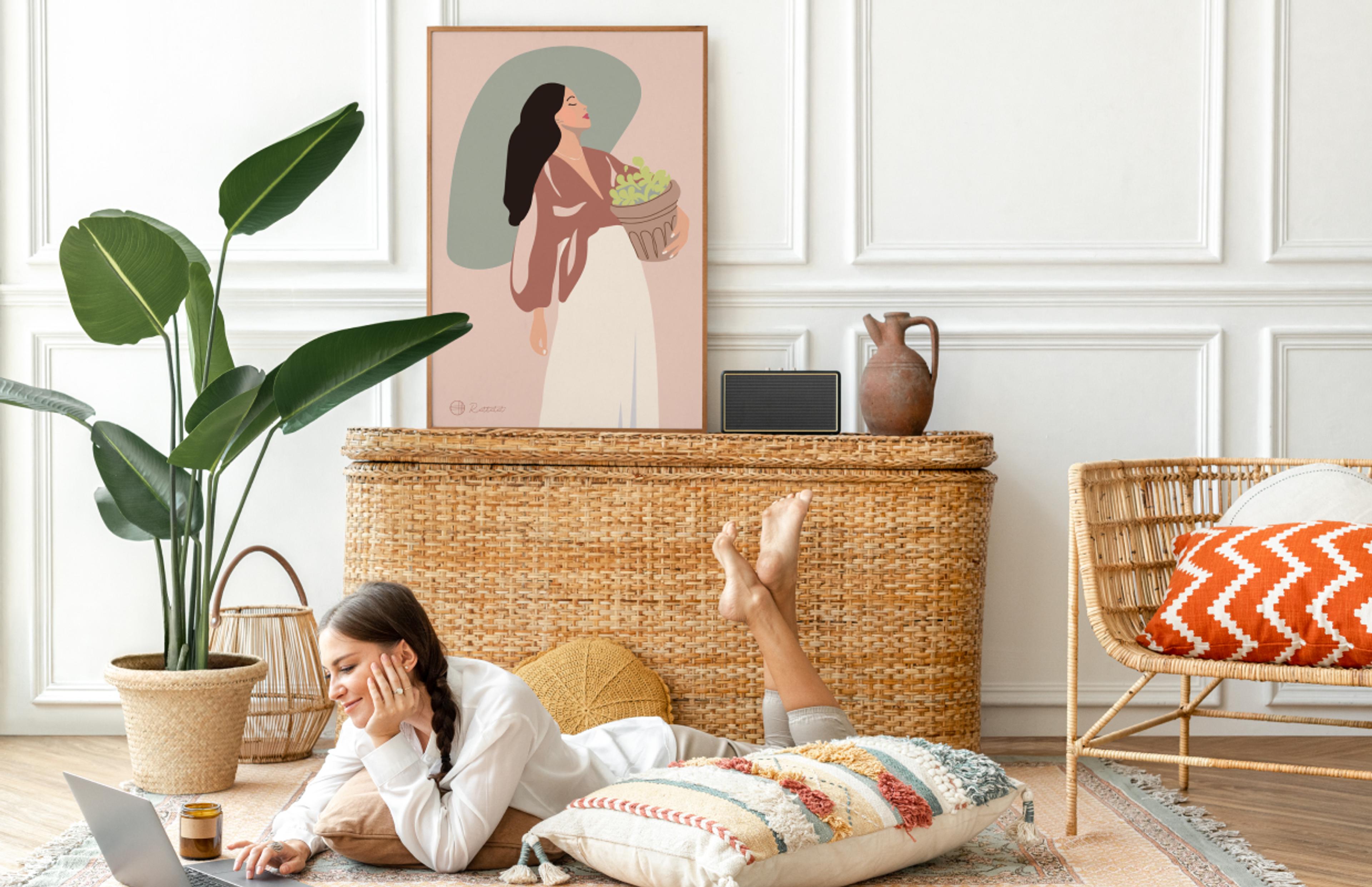 Wohnzimmer mit natürlichem Rattandekor, handgemaltem Poster einer Frau und gemütlicher Atmosphäre – harmonisch und hochwertig gestaltet von Unerwartet Design.