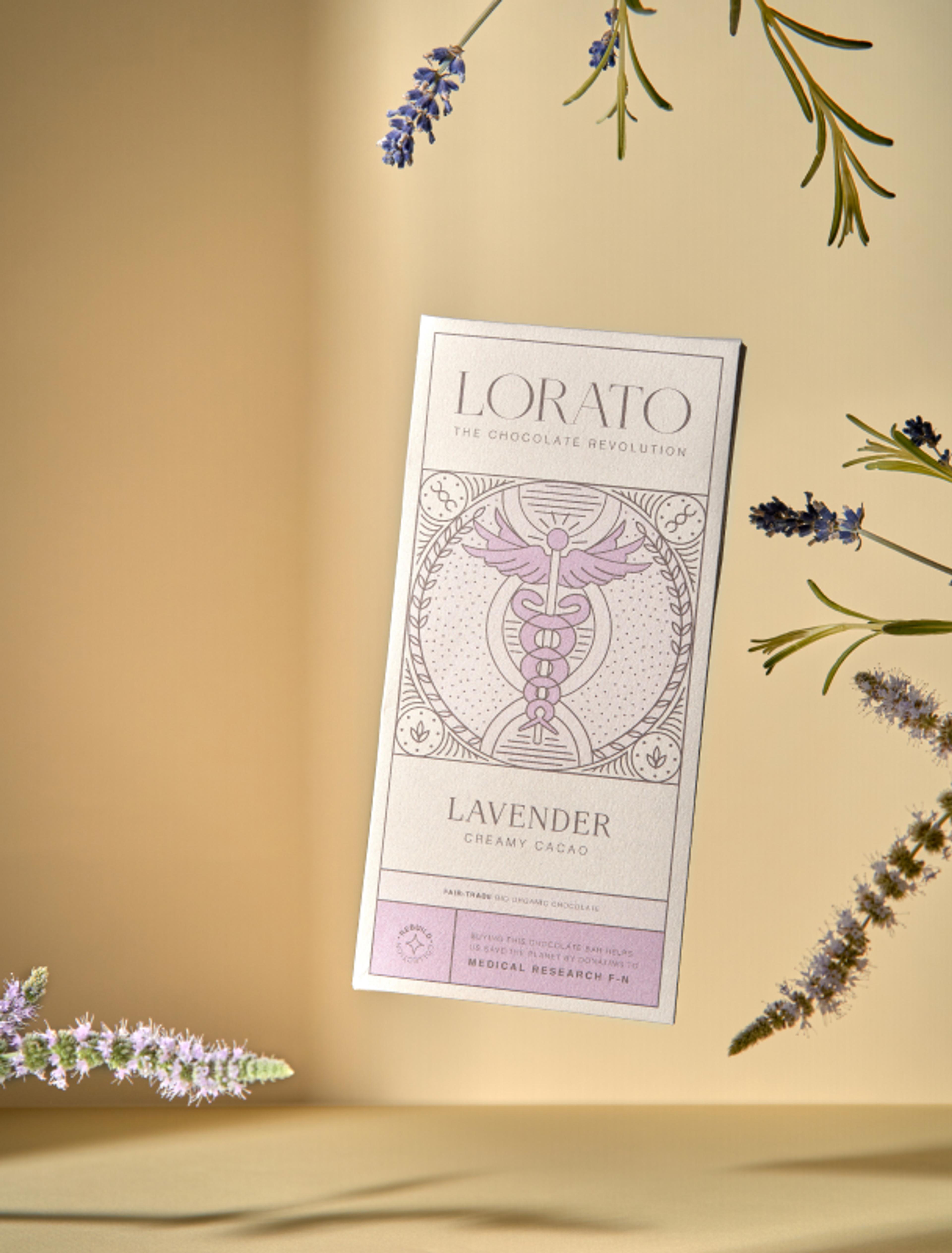 Lorato Lavender Schokolade mit eleganter Caduceus-Symbolik, medizinischer Bezug für Charity-Forschung. Nachhaltiges Verpackungsdesign mit feiner Linienzeichnung.
