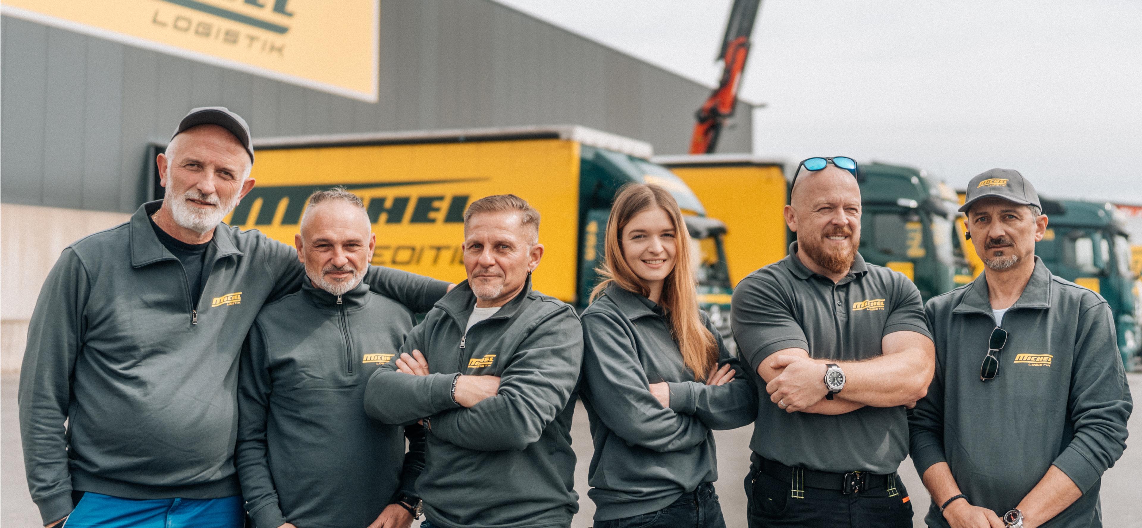 Teamfoto von Michel Logistik mit dem neuen Corporate Design, eingefangen von Unerwartet Design. Die Mitarbeiter:innen stehen vor den gebrandeten LKWs und vermitteln Professionalität und Gemeinschaft