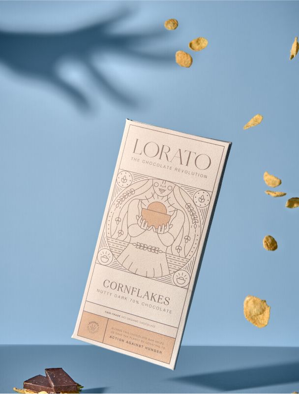 Die Cornflakes Schokoladentafel von Lorato in goldenen Farbtönen. Eine traditionelle Illustration zeigt eine Figur mit einer Schale Cornflakes.