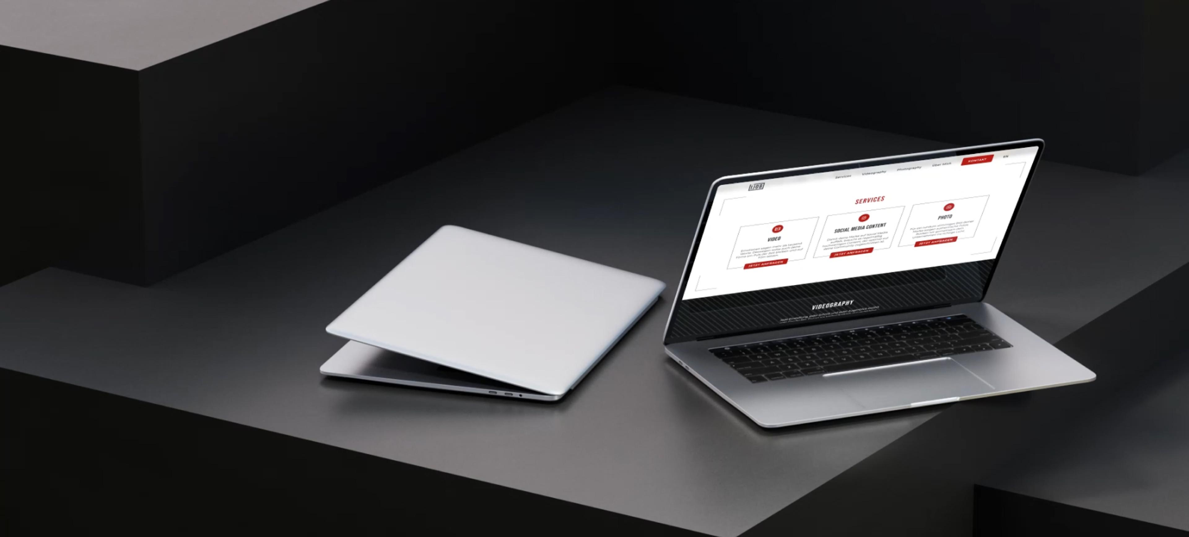 Laptop mit geöffneter Ijob-Website – Ein modernes MacBook mit geöffneter Ijob-Website, das verschiedene Services zeigt. Daneben liegt ein geschlossenes Laptop auf einer minimalistischen, dunklen Oberfläche.