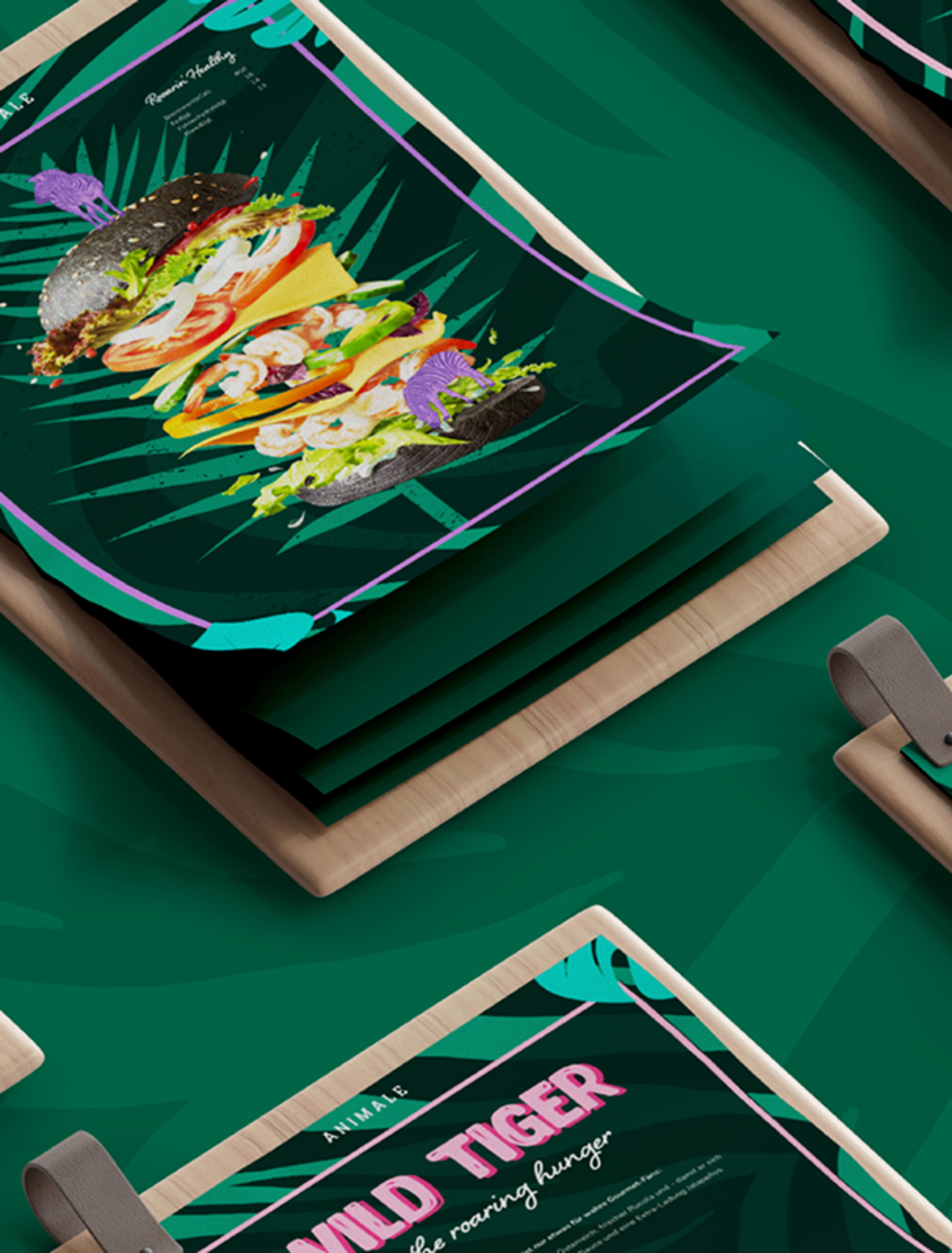 Mehrere Speisekarten des Restaurants Animale mit exotischem Dschungelmotiv und einem Burger mit schwarzem Bun, Garnelen und Gemüse.