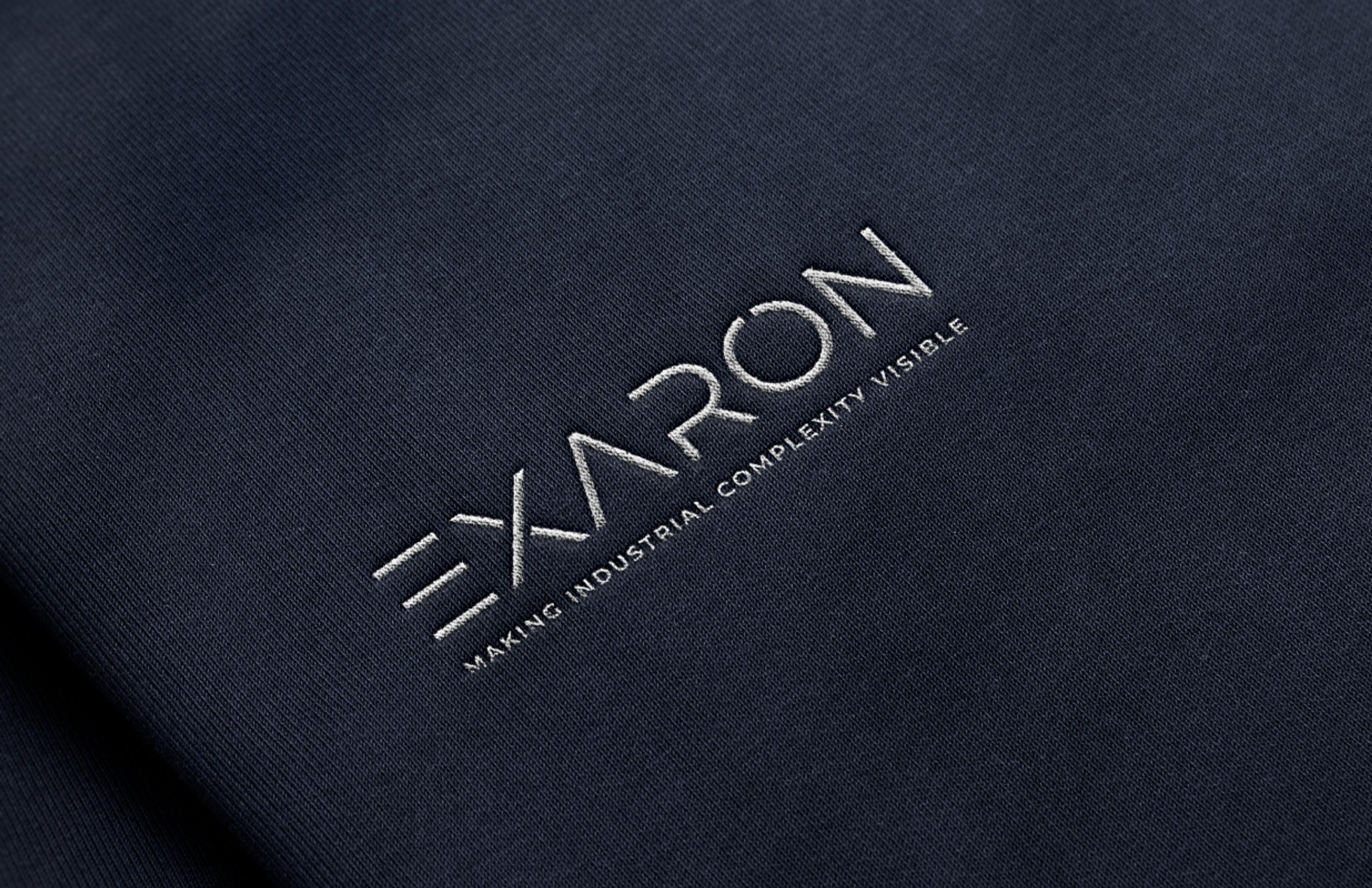 Gesticktes Exaron-Logo auf dunklem Stoff, entworfen von Unerwartet Design, das Präzision, Modernität und technologische Exzellenz vermittelt.