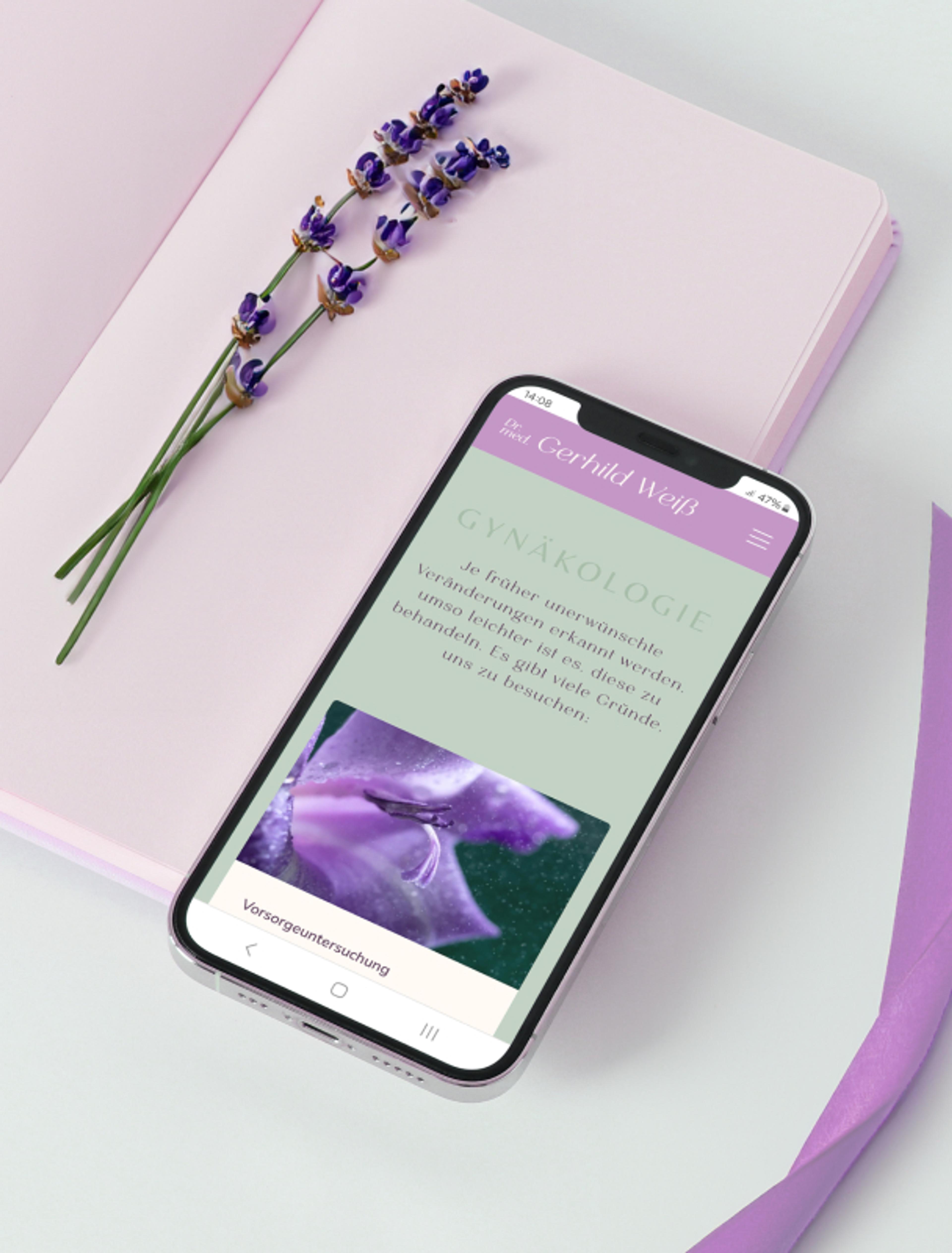 Smartphone mit der Gynäkologie-Seite der von Unerwartet Design in Graz gestalteten Website von Dr. med. Gerhild Weiß, mit Lavendel- und Blumenmotiven.
