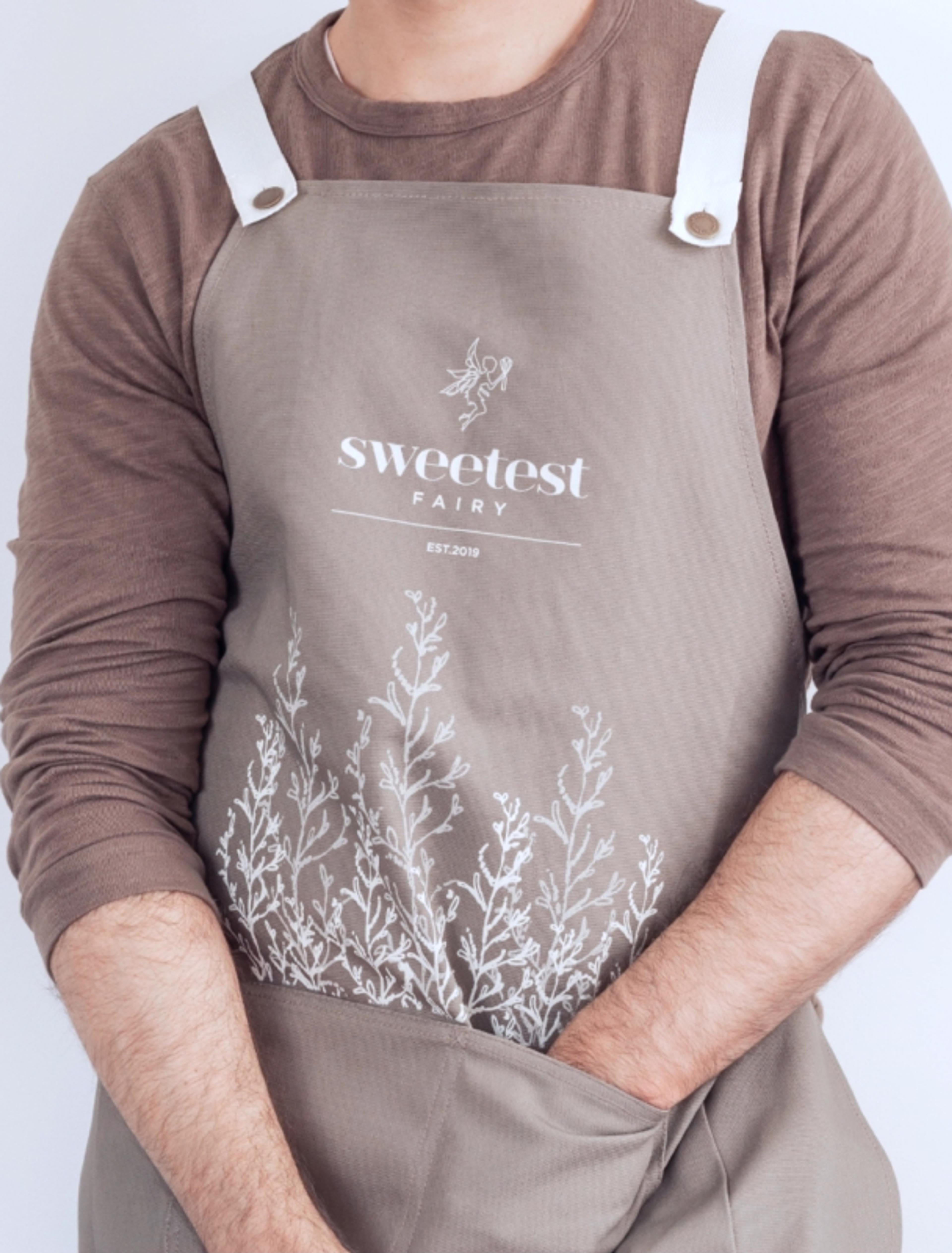 Sweetest Fairy | Sarah Frost Hochwertige, nachhaltig produzierte Schürzen im Corporate Design von Sweetest Fairy. Minimalistisches Branding mit filigranen botanischen Elementen. Erstellt von Unerwartet Design in Graz für das neuseeländische Unternehmen.