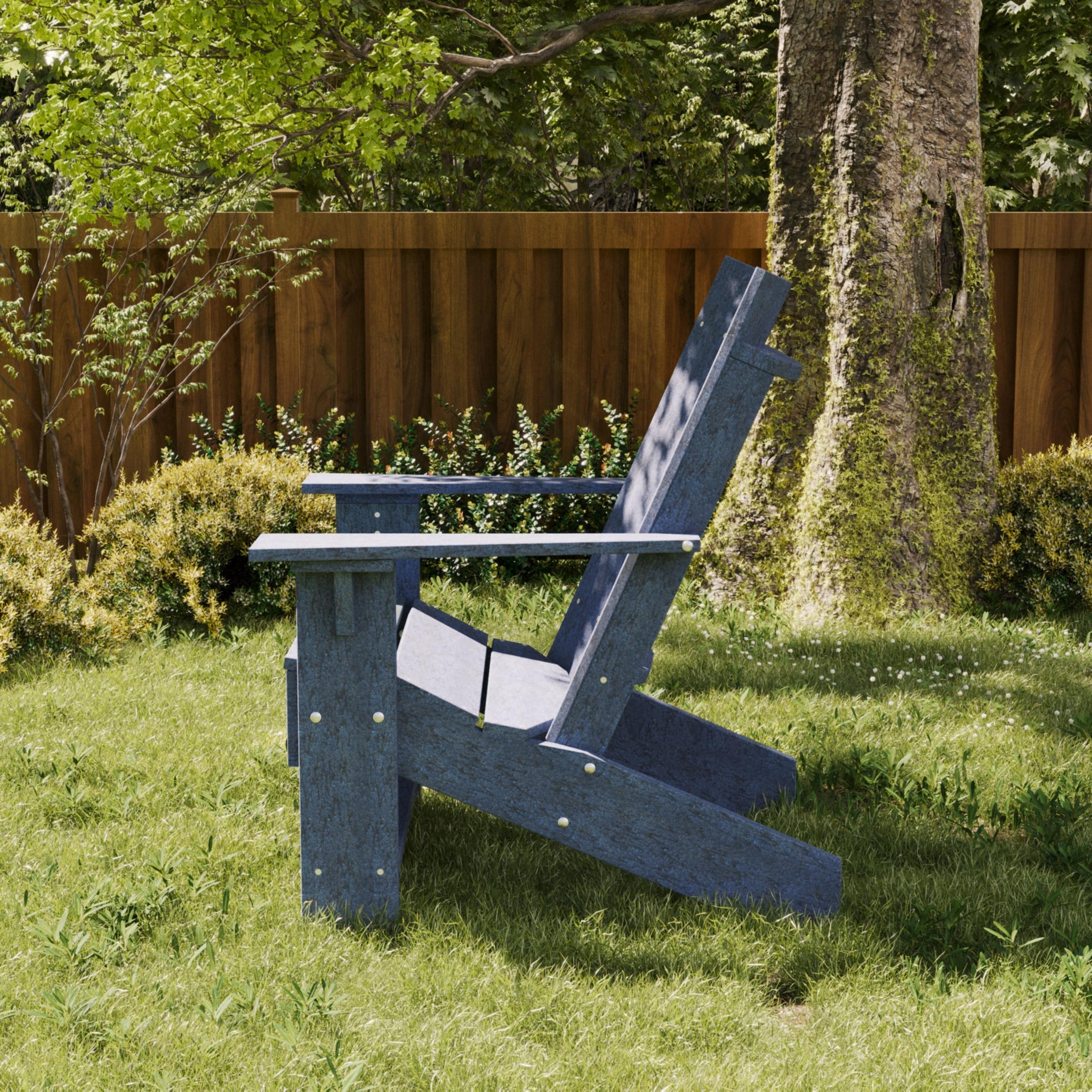 Blue poly Adirondack chair on a grassy lawn near a tree and wooden fence, offering classic style and long-lasting outdoor durability.