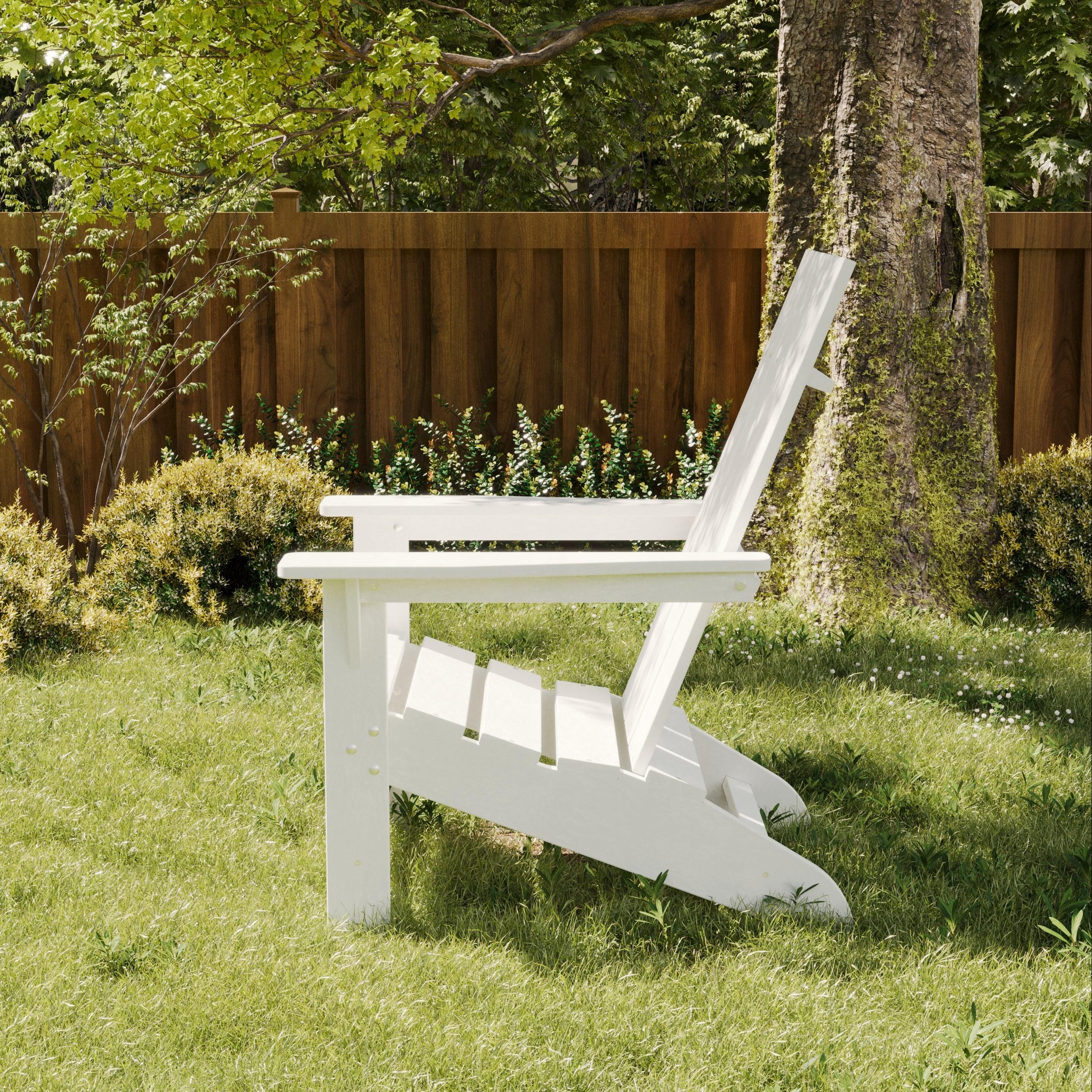 Wildridge Freedom Modern white poly Adirondack chair on a grassy lawn near a tree and wooden fence, designed for lasting outdoor comfort and style.
