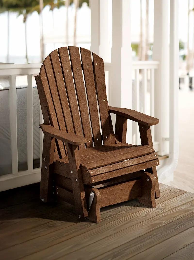 Brown Adirondack glider chair with slatted back and wide arms on a wooden porch