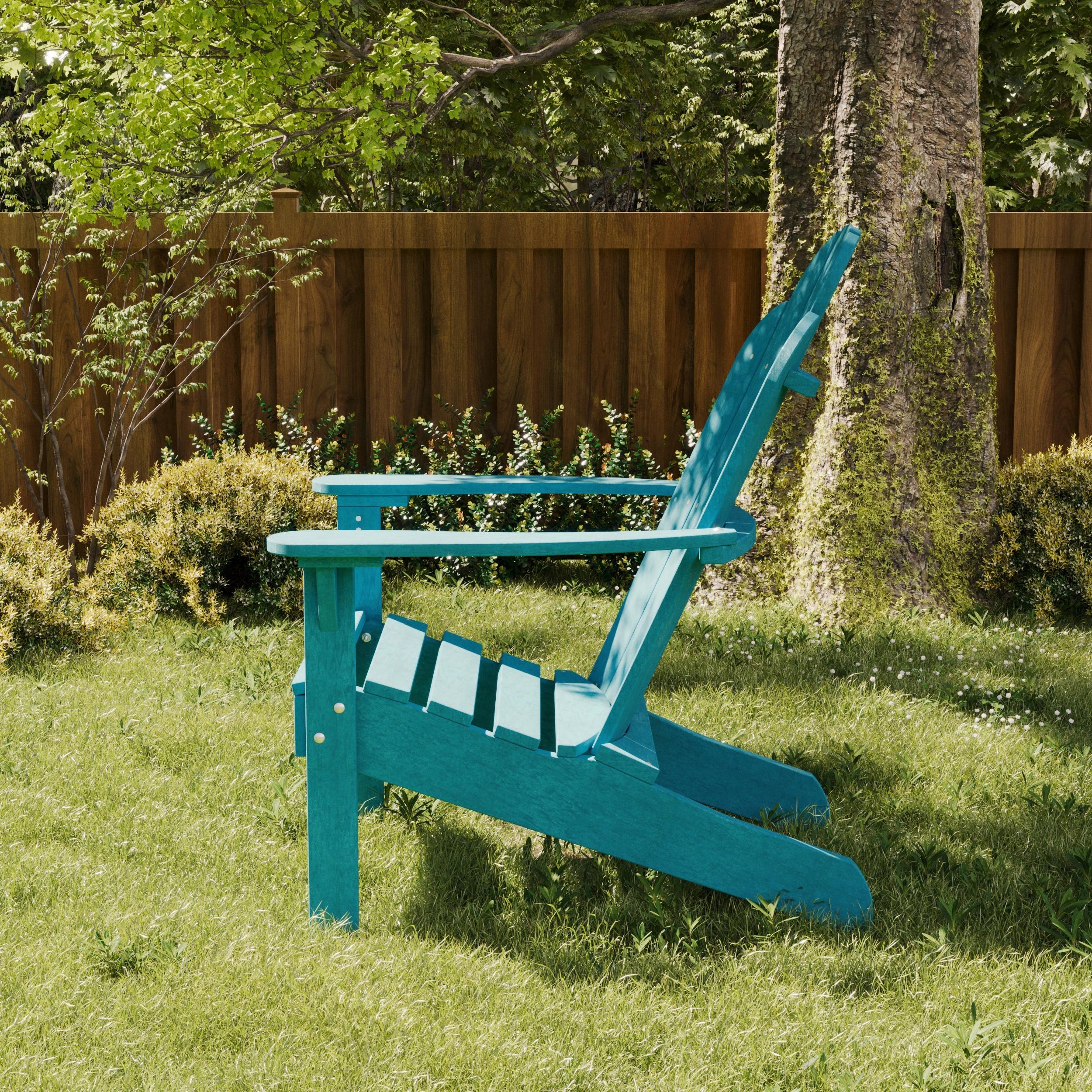 Turquoise poly Adirondack chair on a grassy lawn near a tree and wooden fence, designed for stylish and long-lasting outdoor comfort.