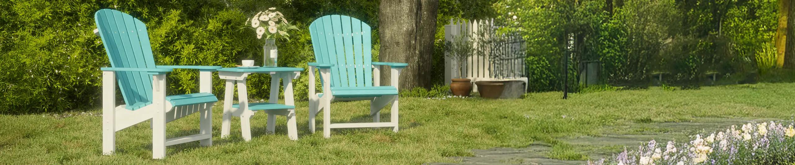 Outdoor patio set with two turquoise Adirondack chairs and table in a garden