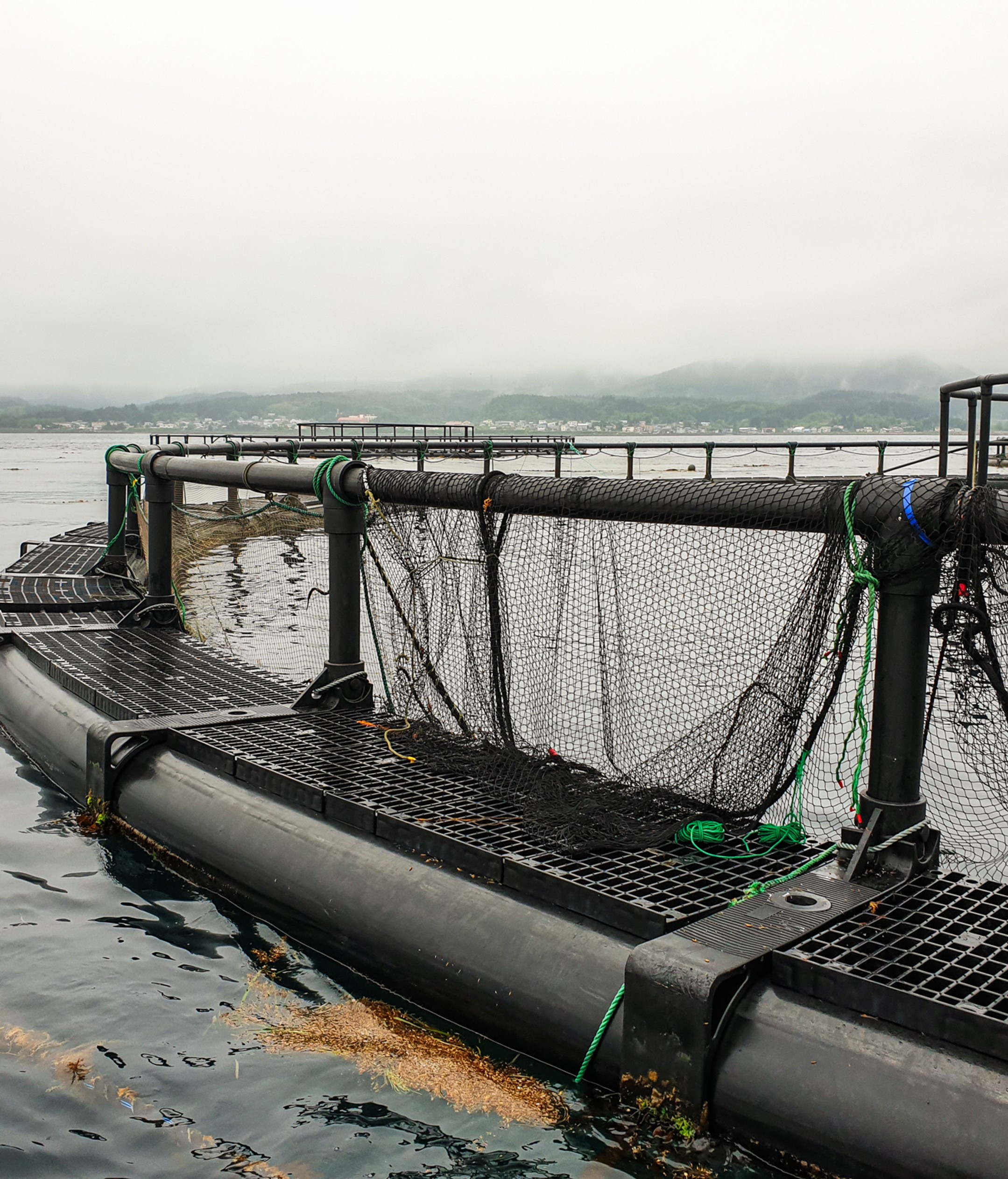 Close-up view of an HD450 fish farming pen showing robust brackets, wide walkway panels and integrated sinker tube sleeve designed for large aquaculture installations.