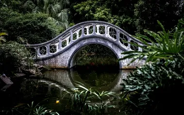 A graceful bridge connecting two sides over peaceful water, representing how strategic communication maintains relationships while setting boundaries