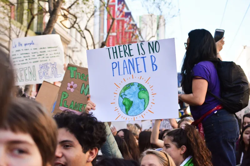 Climate protest with 'There Is No Planet B' sign, illustrating the environmental imperative driving sustainable digital transformation practices