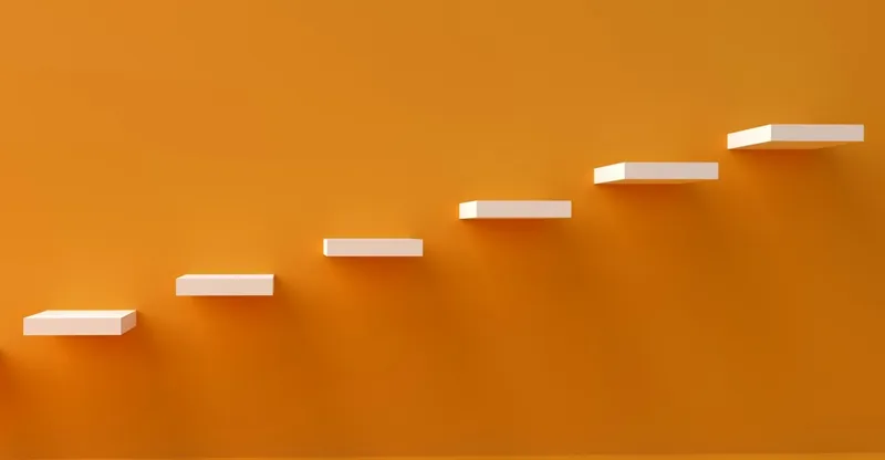 Ascending white steps on orange background illustrating management hierarchy progression