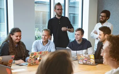 Diverse team meeting with multiple generations collaborating in modern office