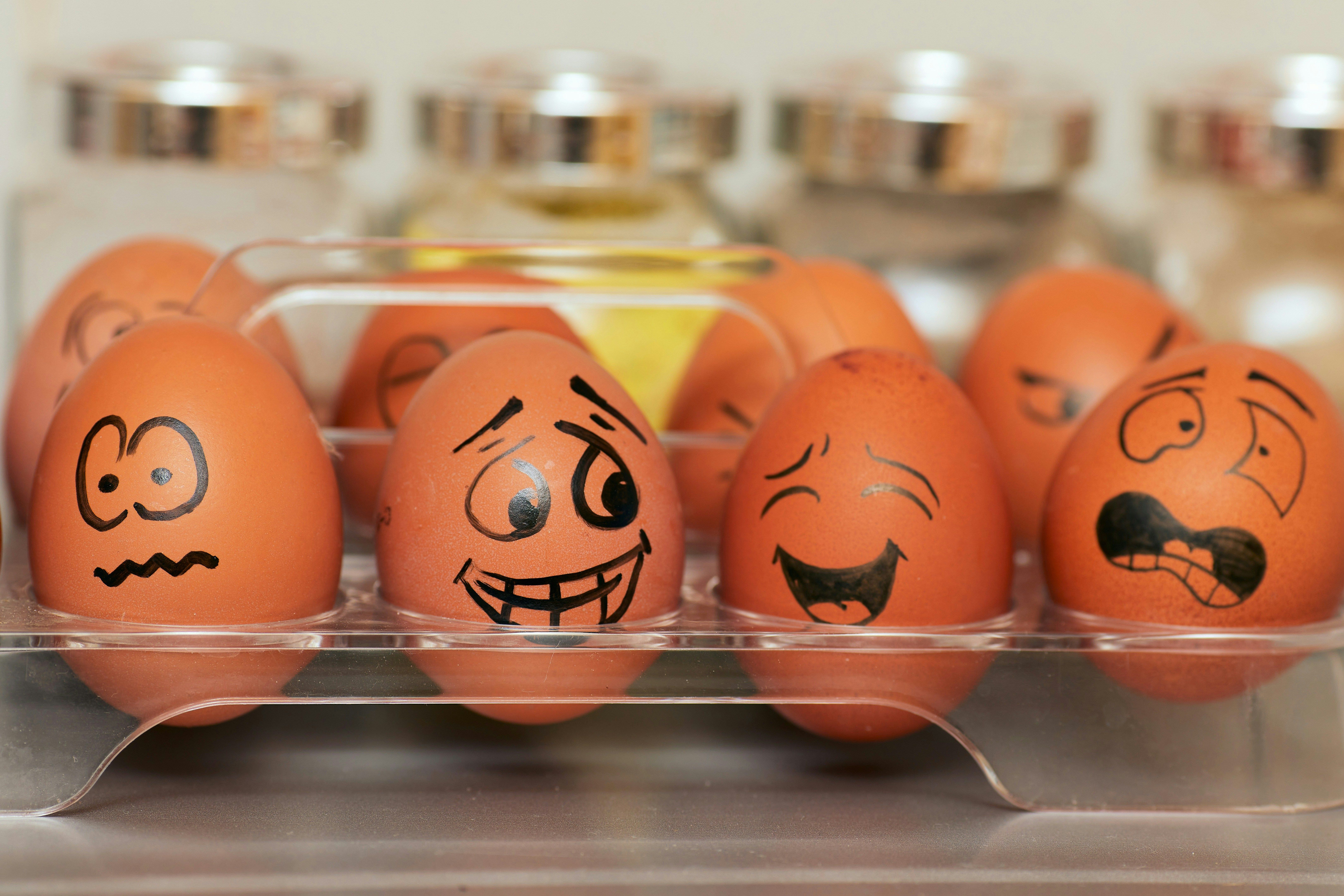 Eggs with various emotional expressions drawn on them, illustrating the emotional awareness skills that technical leaders must develop to manage teams effectively