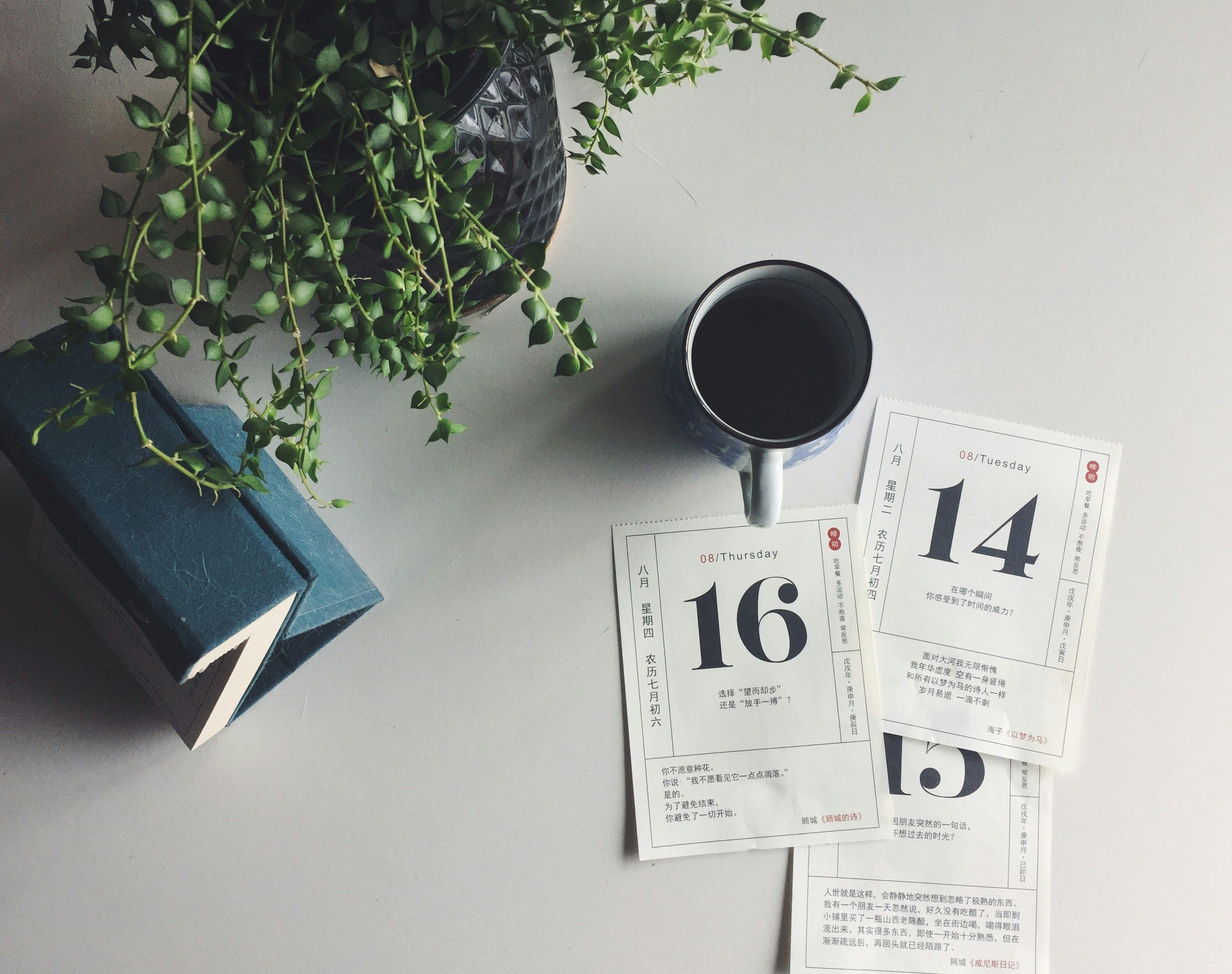 Calendar pages with coffee on desk, representing ongoing workplace conversations rather than formal annual review scheduling