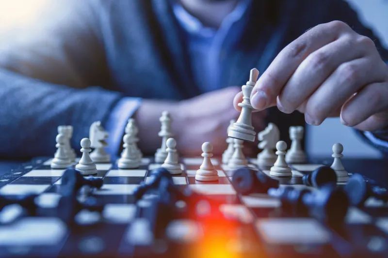 Business professional making strategic chess move, representing thoughtful AI strategy planning