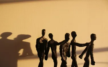 Five weathered figures connected in solidarity, representing resilient inclusion that strengthens through connection