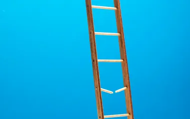 Ladder with broken rung against blue wall, illustrating the career progression gaps that AI has created by replacing traditional entry-level engineering roles