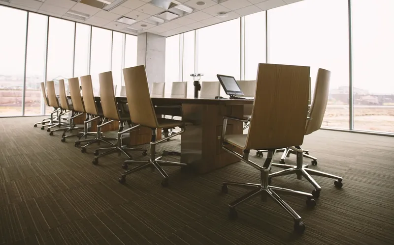 Executive boardroom where technical leaders present engineering decisions to business stakeholders in terms they can understand and evaluate.