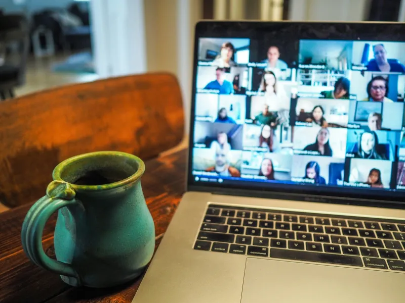 Laptop displaying a video conference call with multiple participants in a grid layout, representing the daily reality of remote team communication challenges