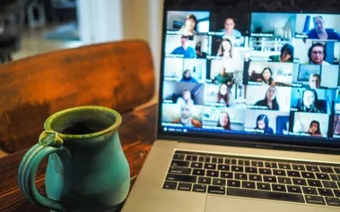 Laptop displaying a video conference call with multiple participants in a grid layout, representing the daily reality of remote team communication challenges