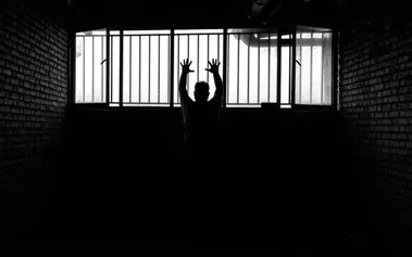 Silhouette of person behind prison bars, symbolising how technical expertise can become a career trap