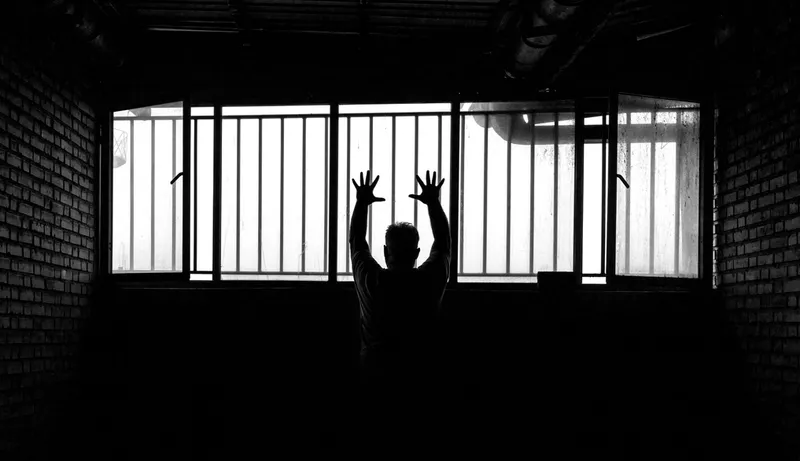 Silhouette of person behind prison bars, symbolising how technical expertise can become a career trap