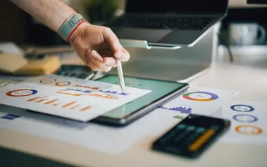 Professional using stylus on tablet with business intelligence, showing superagency leaders blending AI insights with human strategic thinking