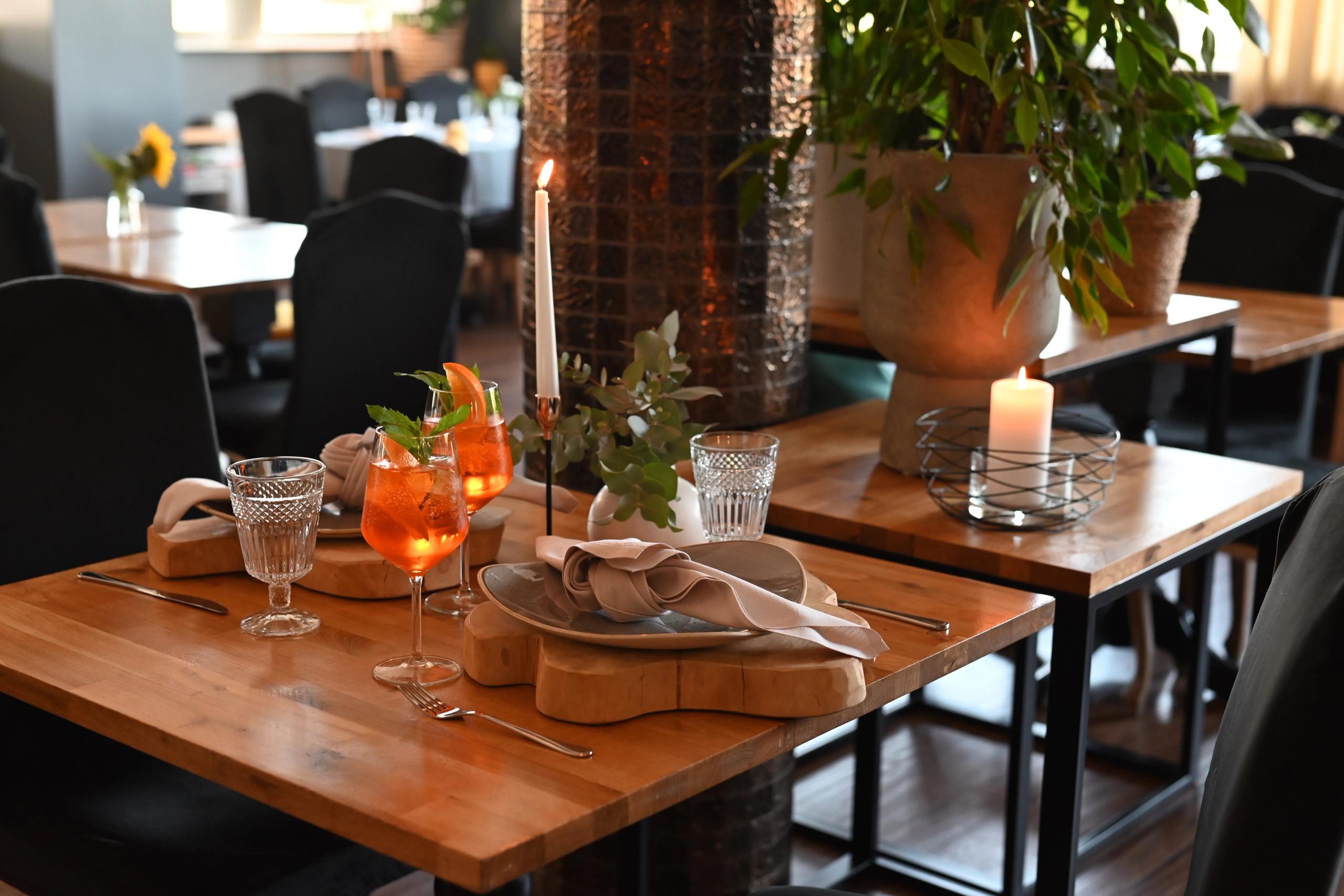 Wnętrze Restauracji Sezam w Stalowej Woli — nakryty stolik z Aperol Spritz i świecami