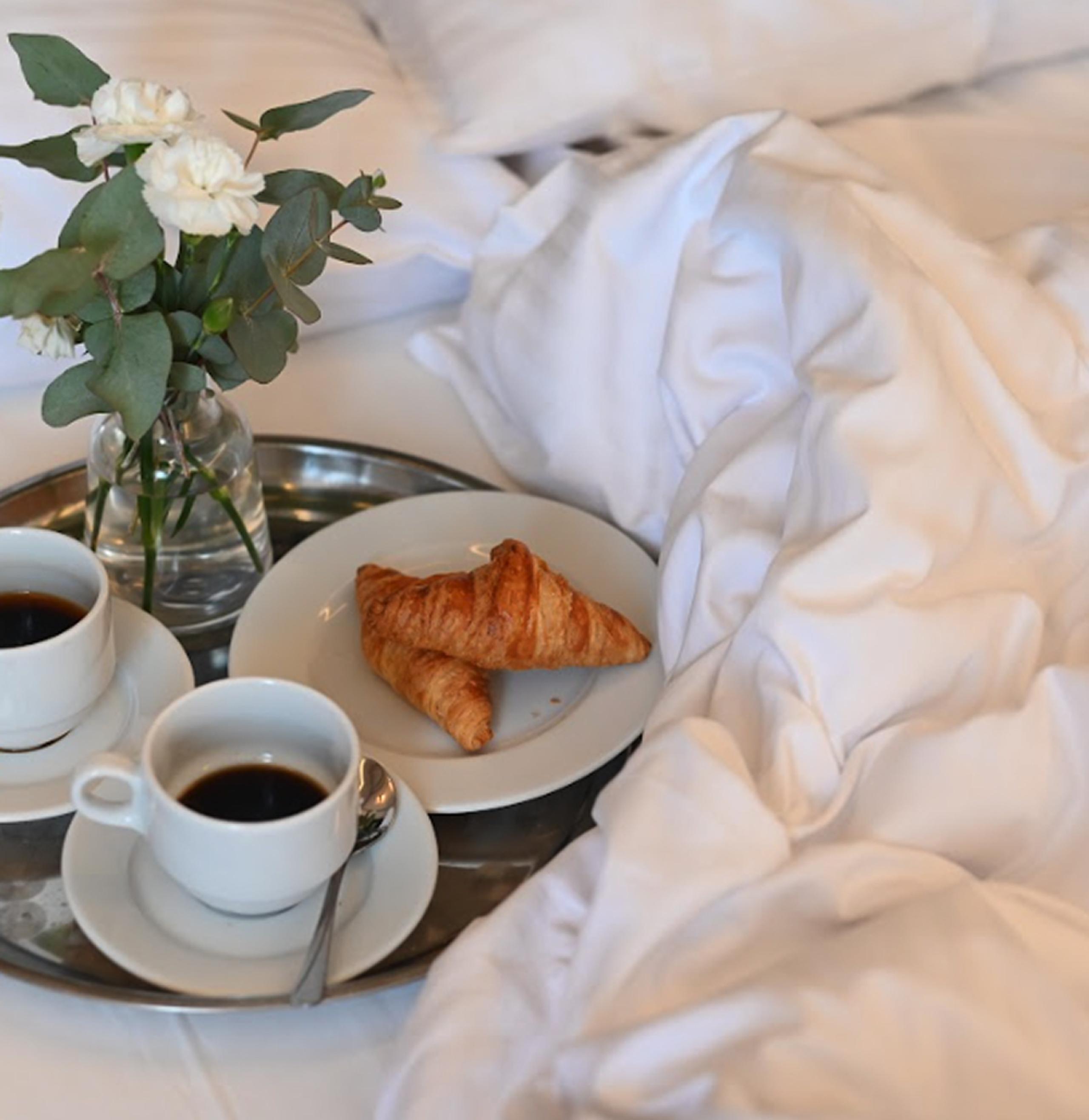 Śniadanie do łóżka w Hotelu Sezam w Stalowej Woli — kawa i croissanty podane na tacy z kwiatami