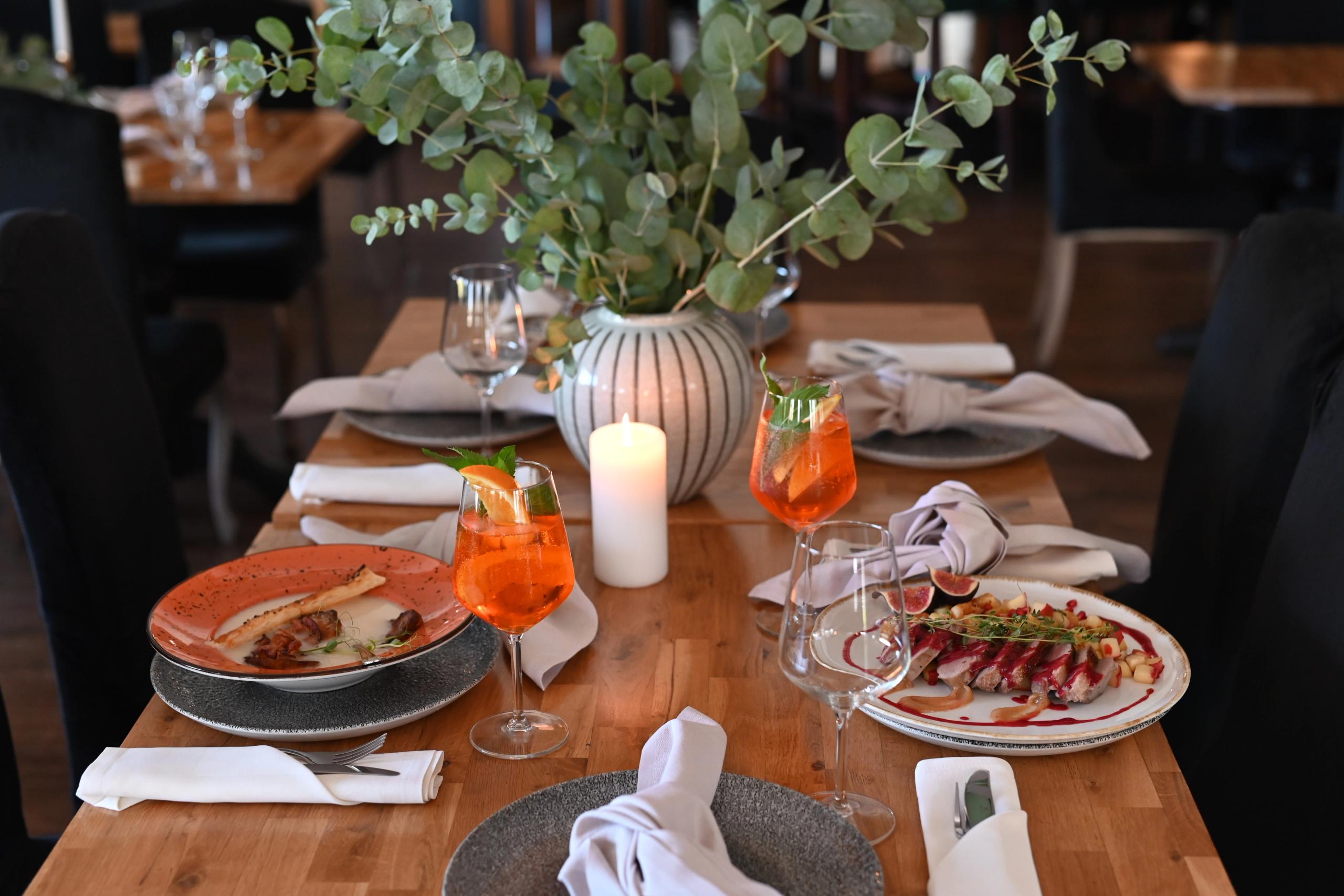Restauracja Sezam w Stalowej Woli — nakryty stół z daniami, Aperol Spritz i dekoracją z eukaliptusa