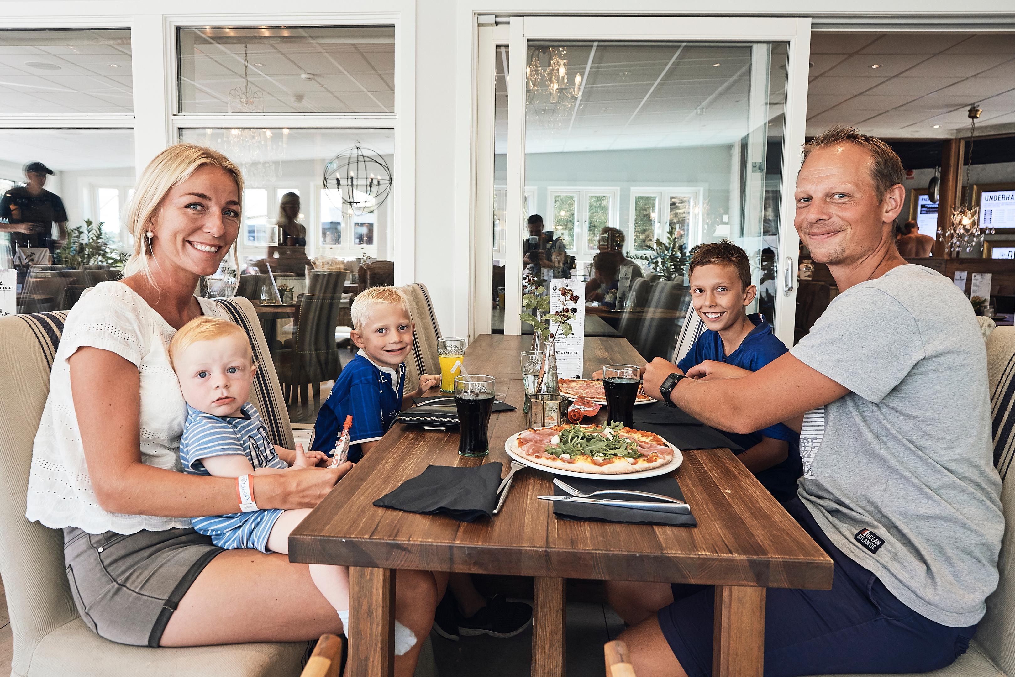 Familie som spiser lunsj i Restaurant Packhusets glassveranda.