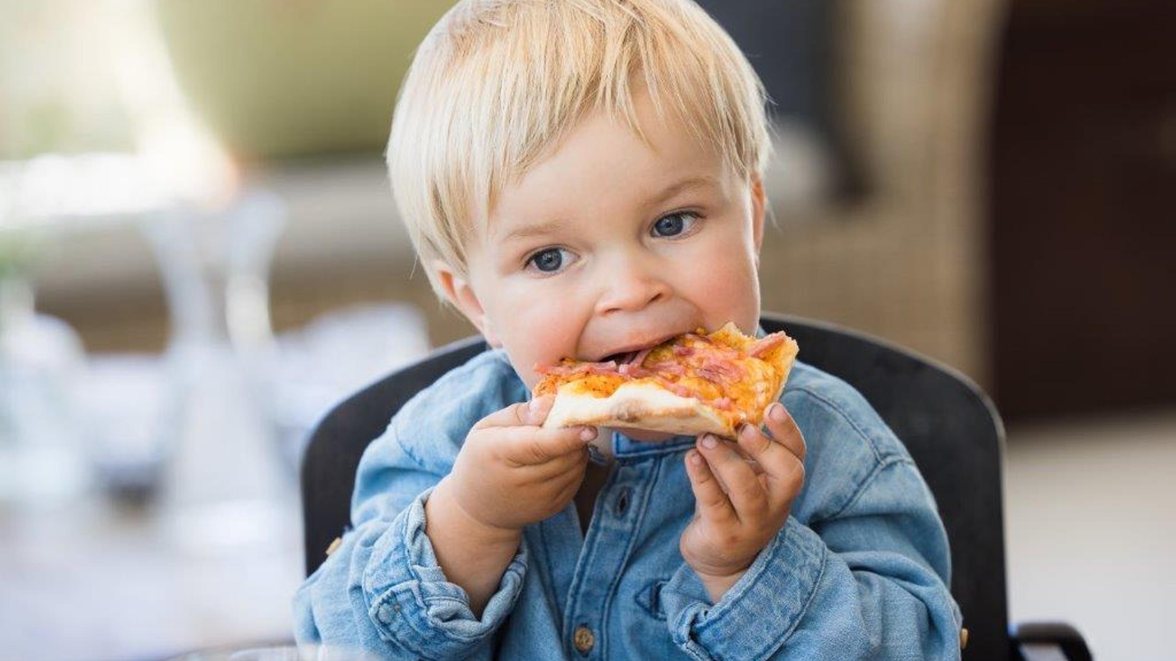 A child eats pizza in the restaurant