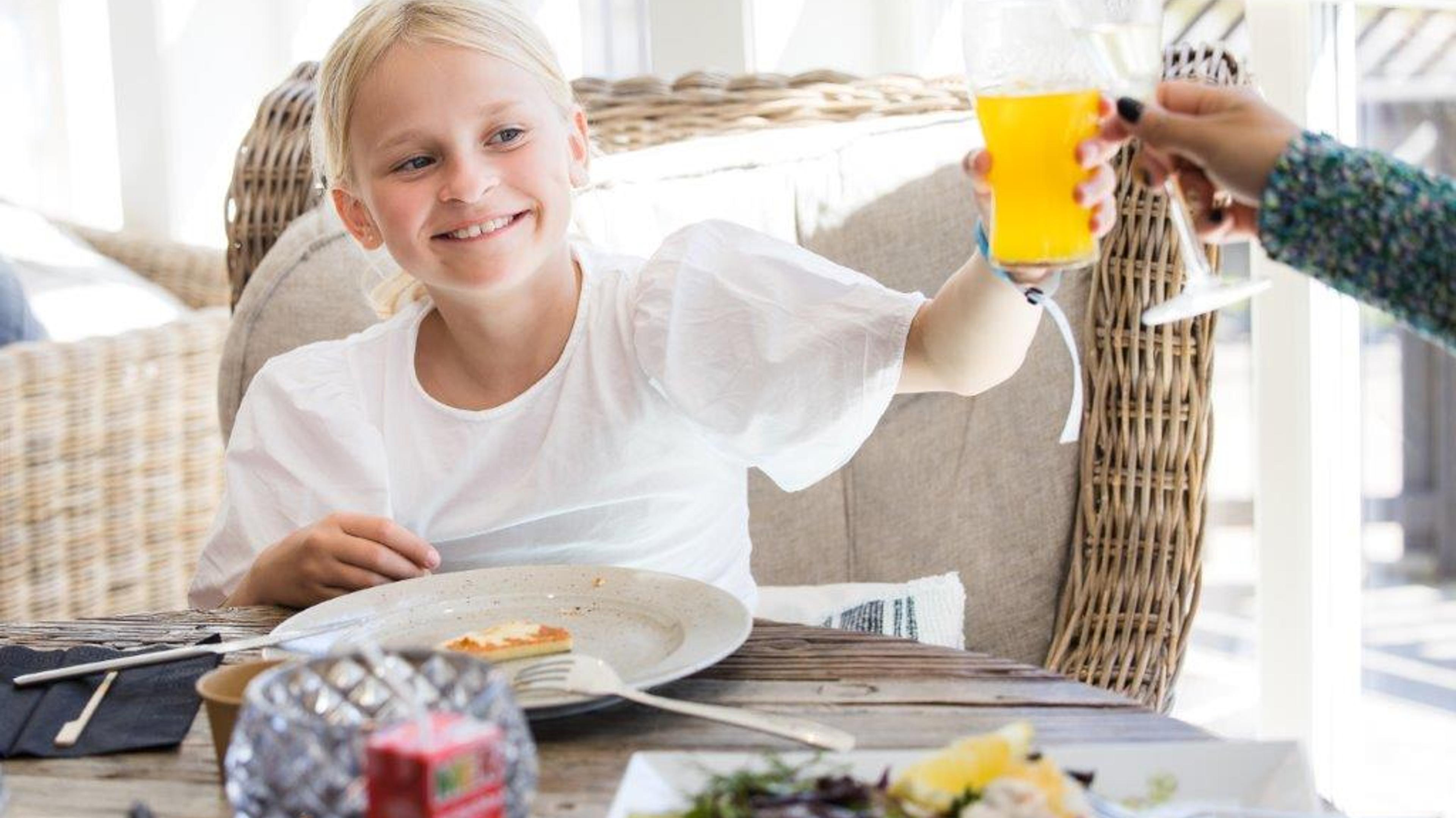 Girl making a toast during a dinner at Restaurant packhuset's glass veranda