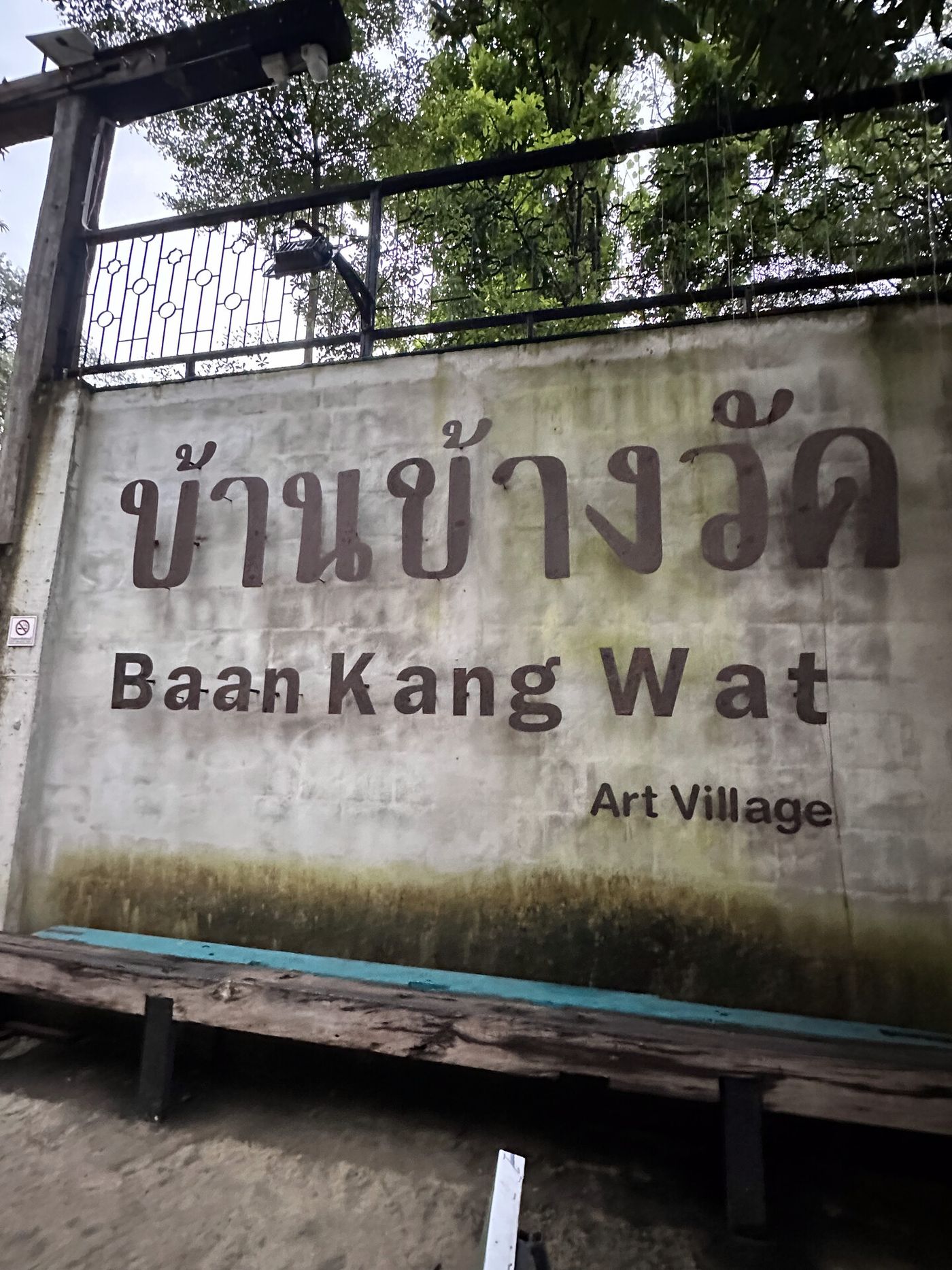 這塊低調到會錯過的招牌,就是入口——「บ้านข้างวัด Baan Kang Wat Art Village」
